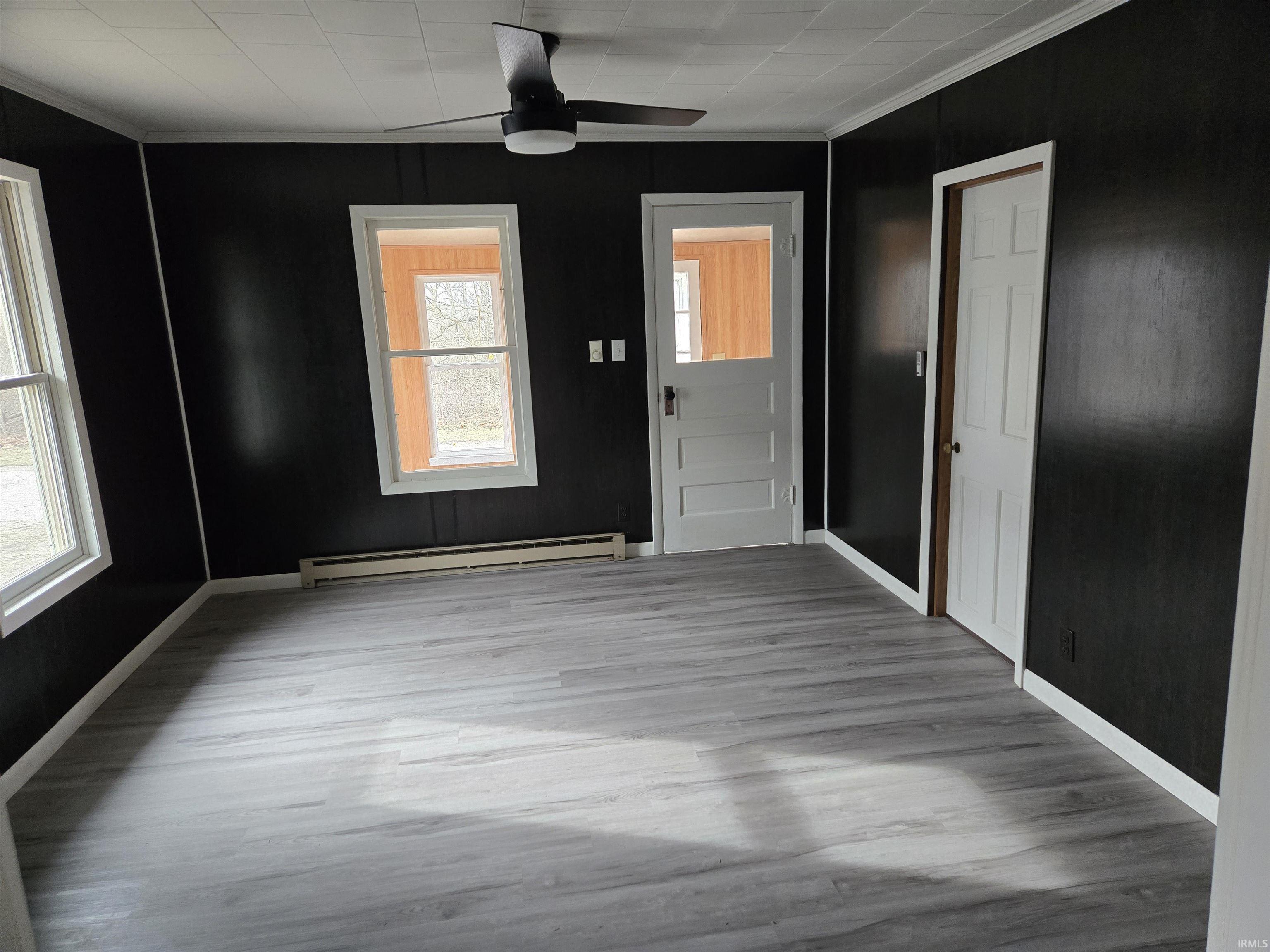 Image 1: Foyer featuring crown molding, a baseboard heating unit, a ceiling fan, and light wood-style floors, Entrance Foyer