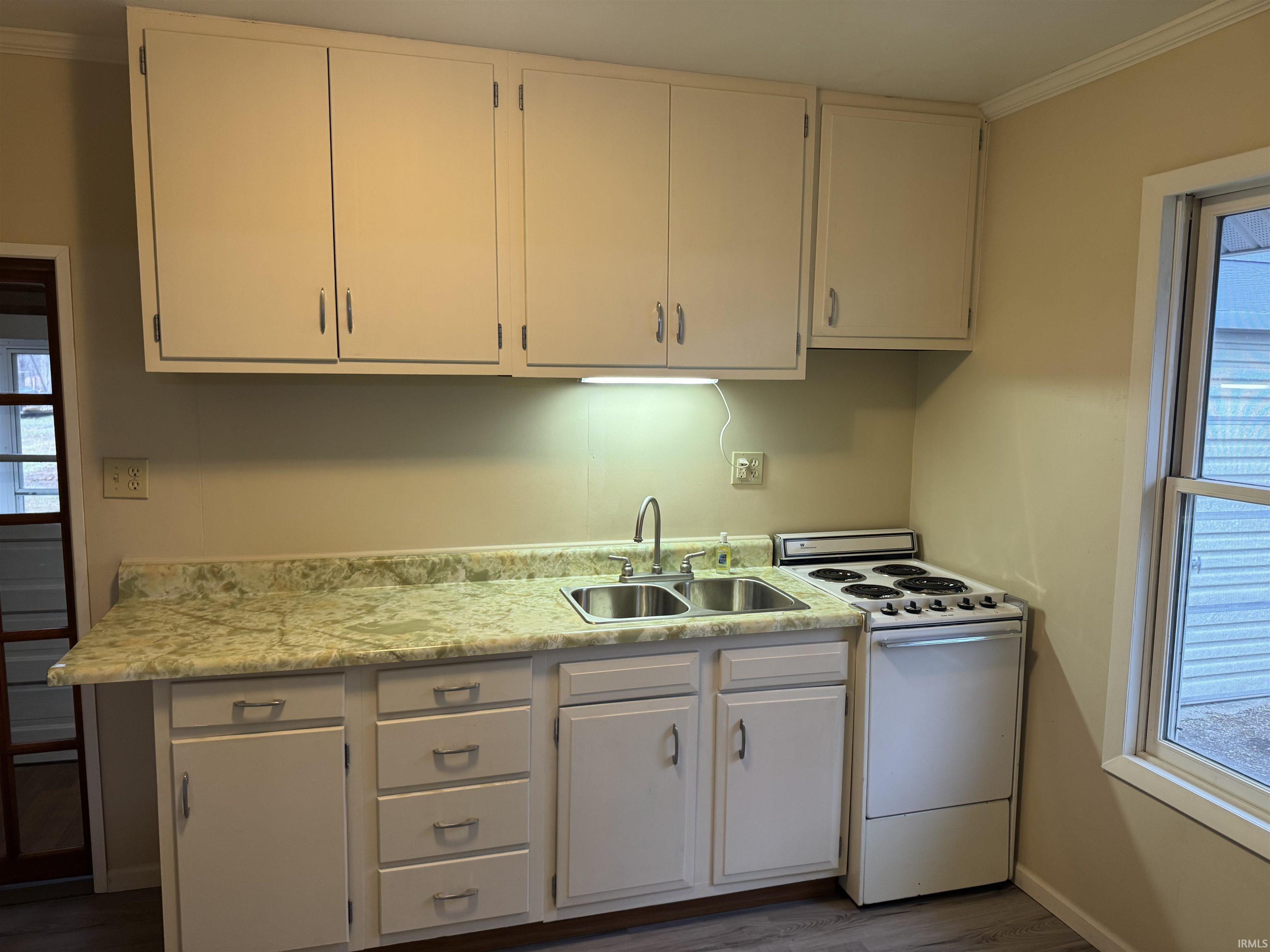 Image 2: Kitchen featuring white range with electric stovetop, light countertops, crown molding, dark wood-style floors, and white cabinetry, Kitchen