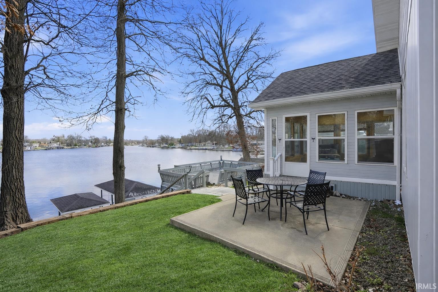 Image 1: View of patio with a water view, outdoor dining space, and a boat dock, Patio