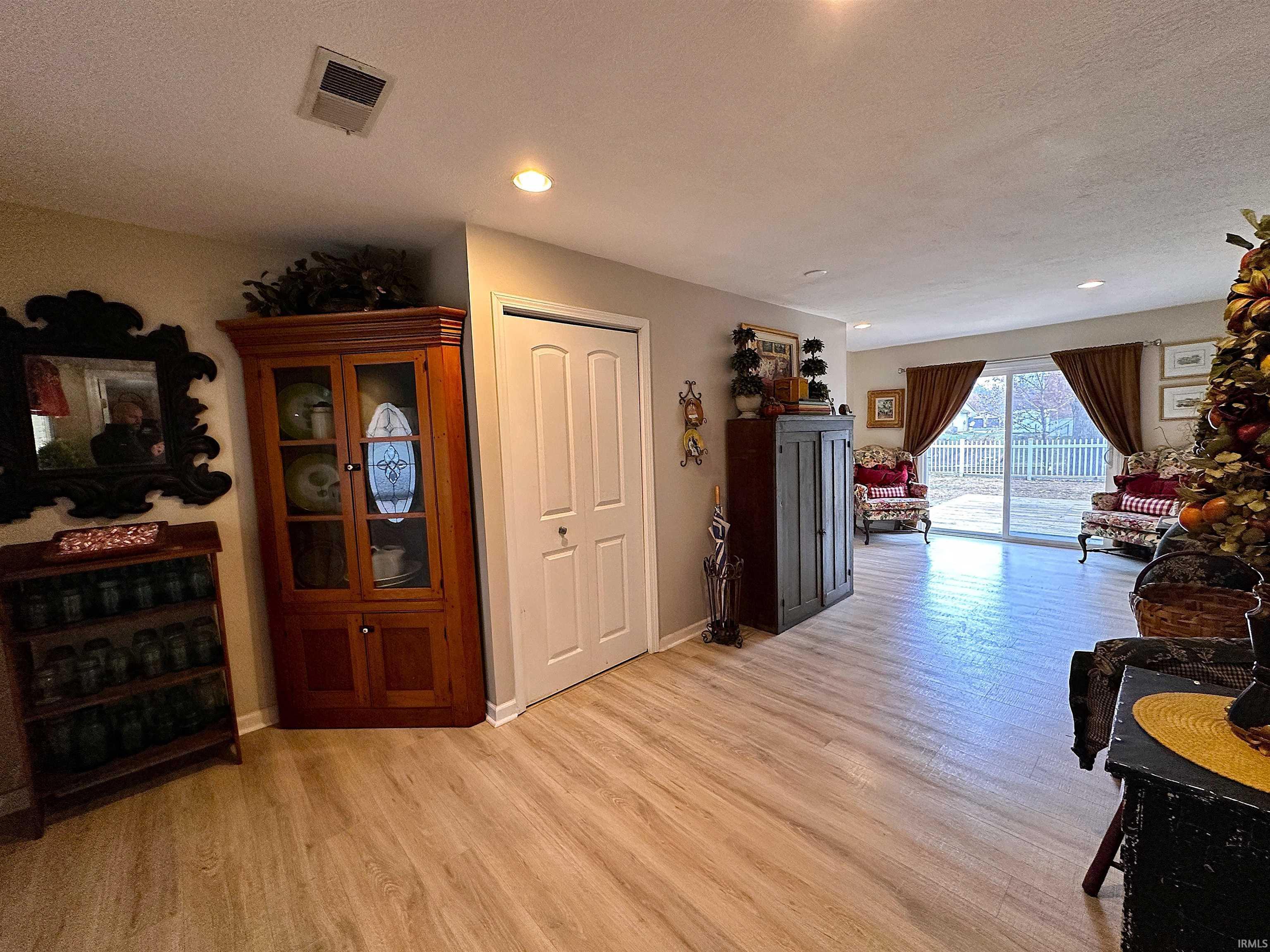 Image 2: Living area with light wood-type flooring, a textured ceiling, and recessed lighting, Living Room