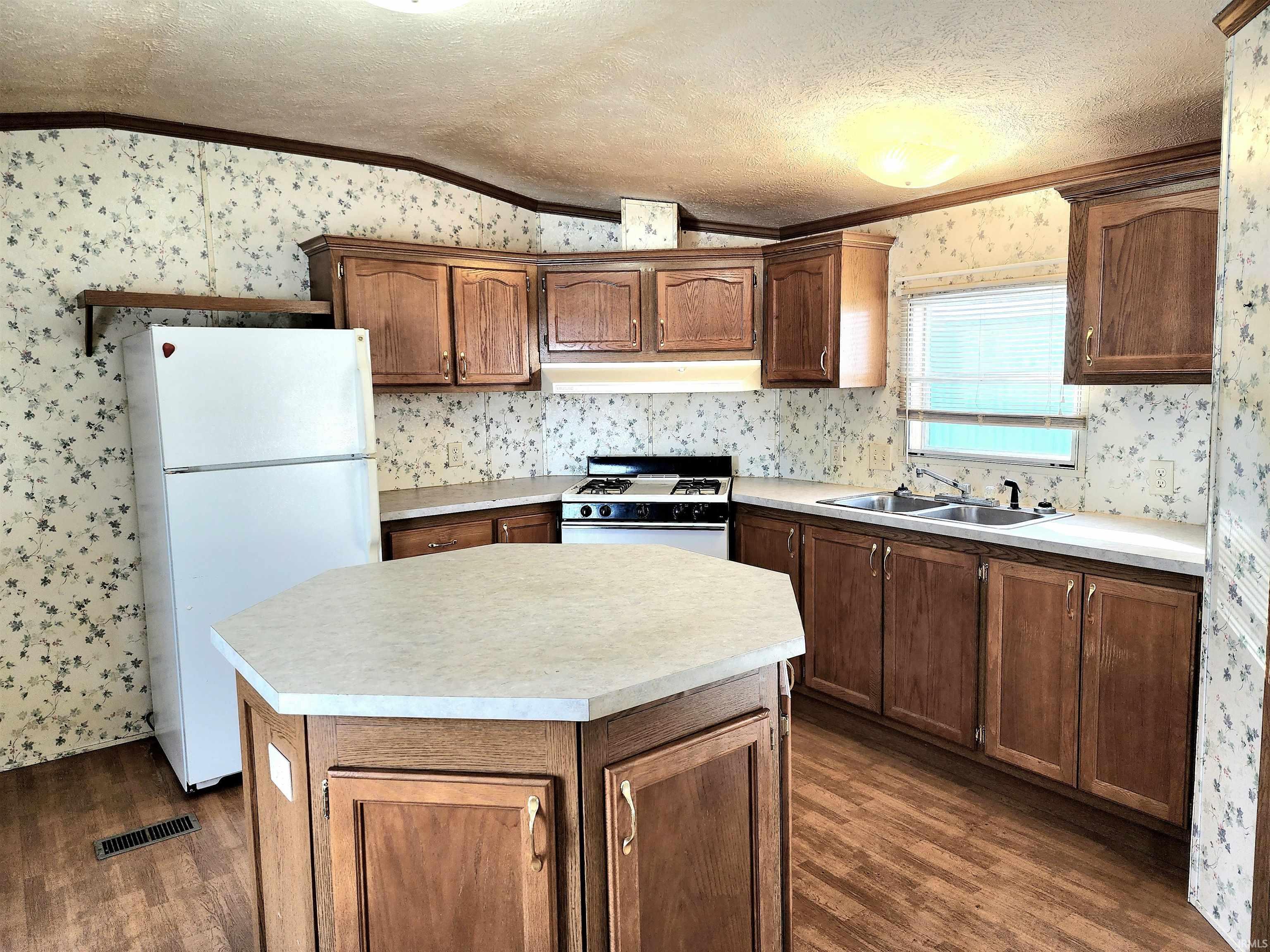 Image 2: Kitchen featuring a large center island, white appliances, plenty of counter space, an abundance of cabinet storage and crown molding, Kitchen