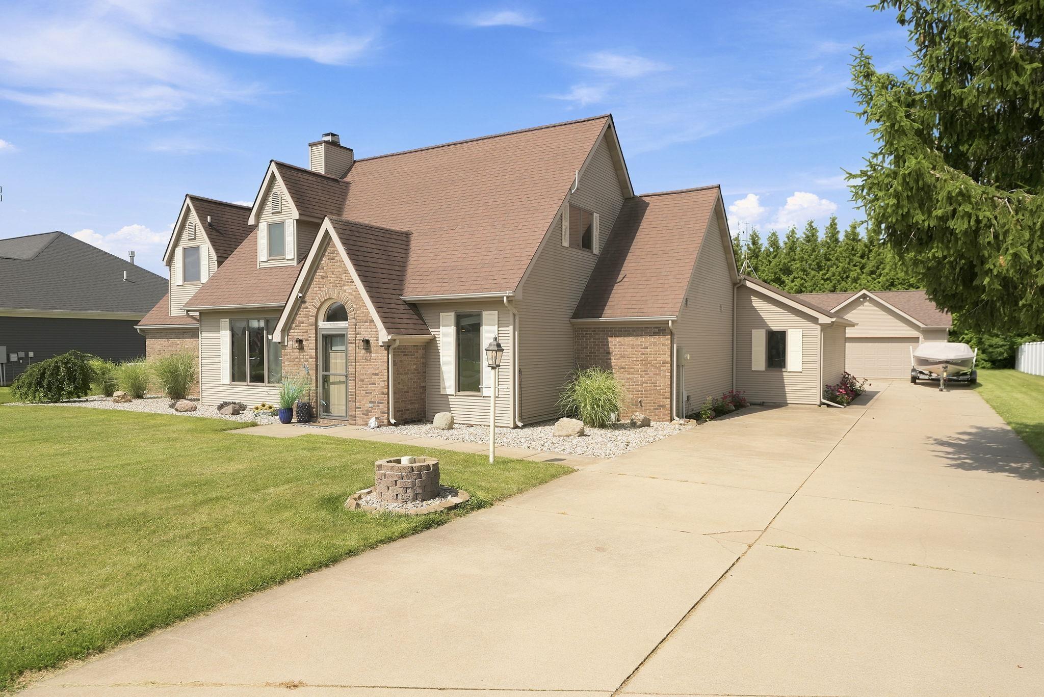 Image 0: Traditional-style residence featuring a brick and stucco exterior, dormer windows, and a prominent arched entry, Front Of Structure