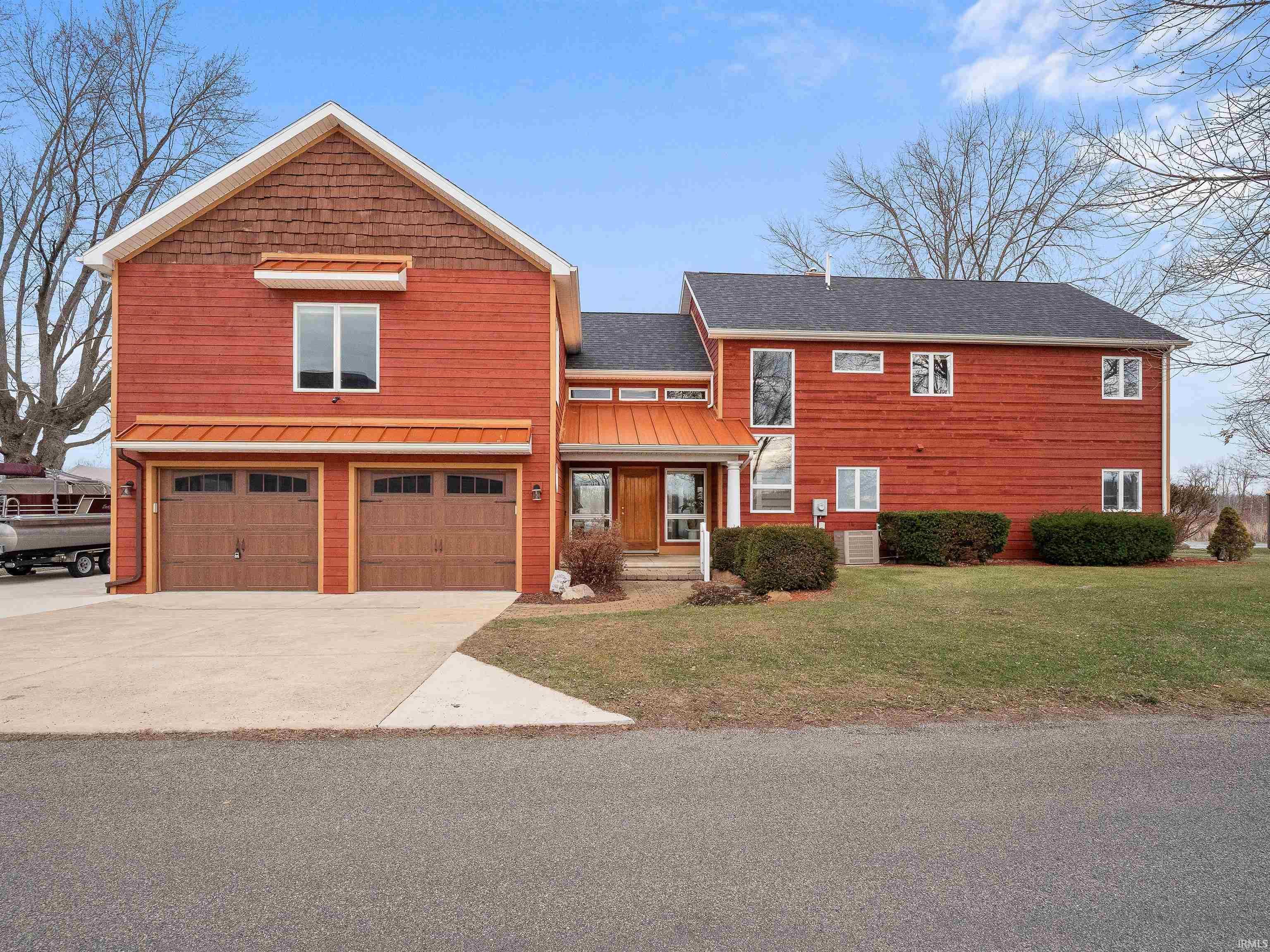 Image 1: Modern two-story residence featuring red siding and a dark shingle roof, Front Of Structure