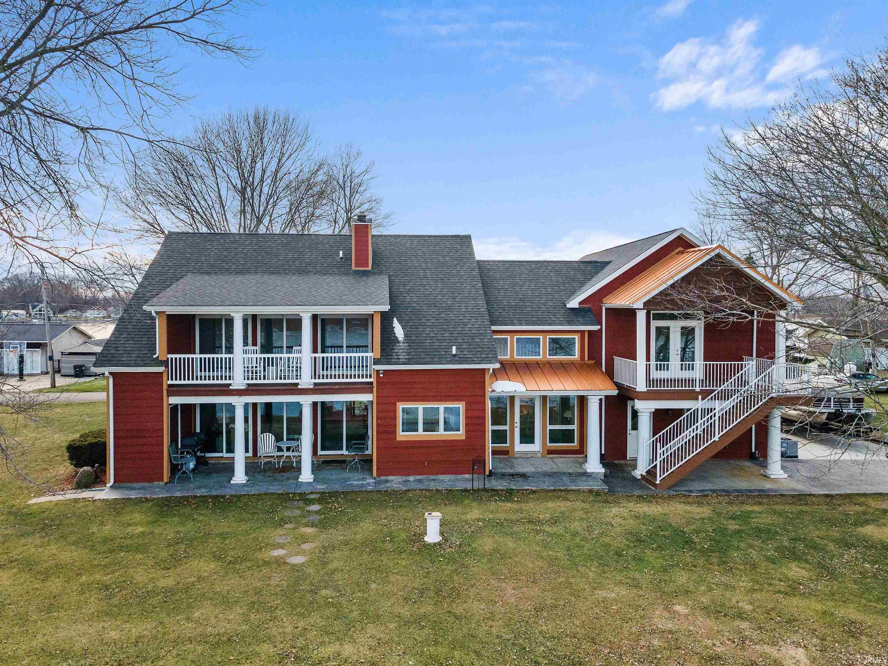 Image 2: Red exterior with multiple balconies and a covered patio, Back Of Structure