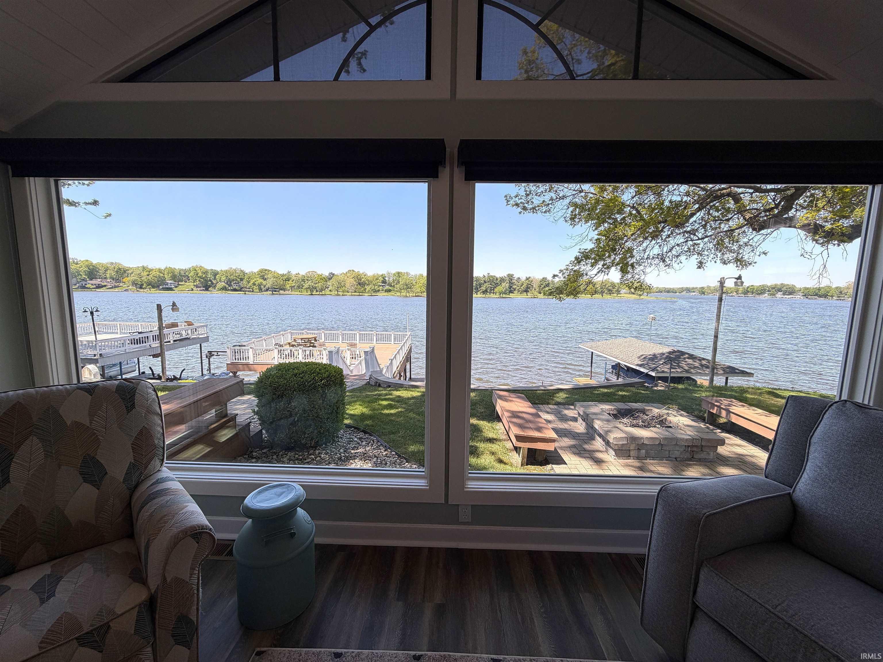 Image 1: Expansive windows overlooking a lake with a private dock, View