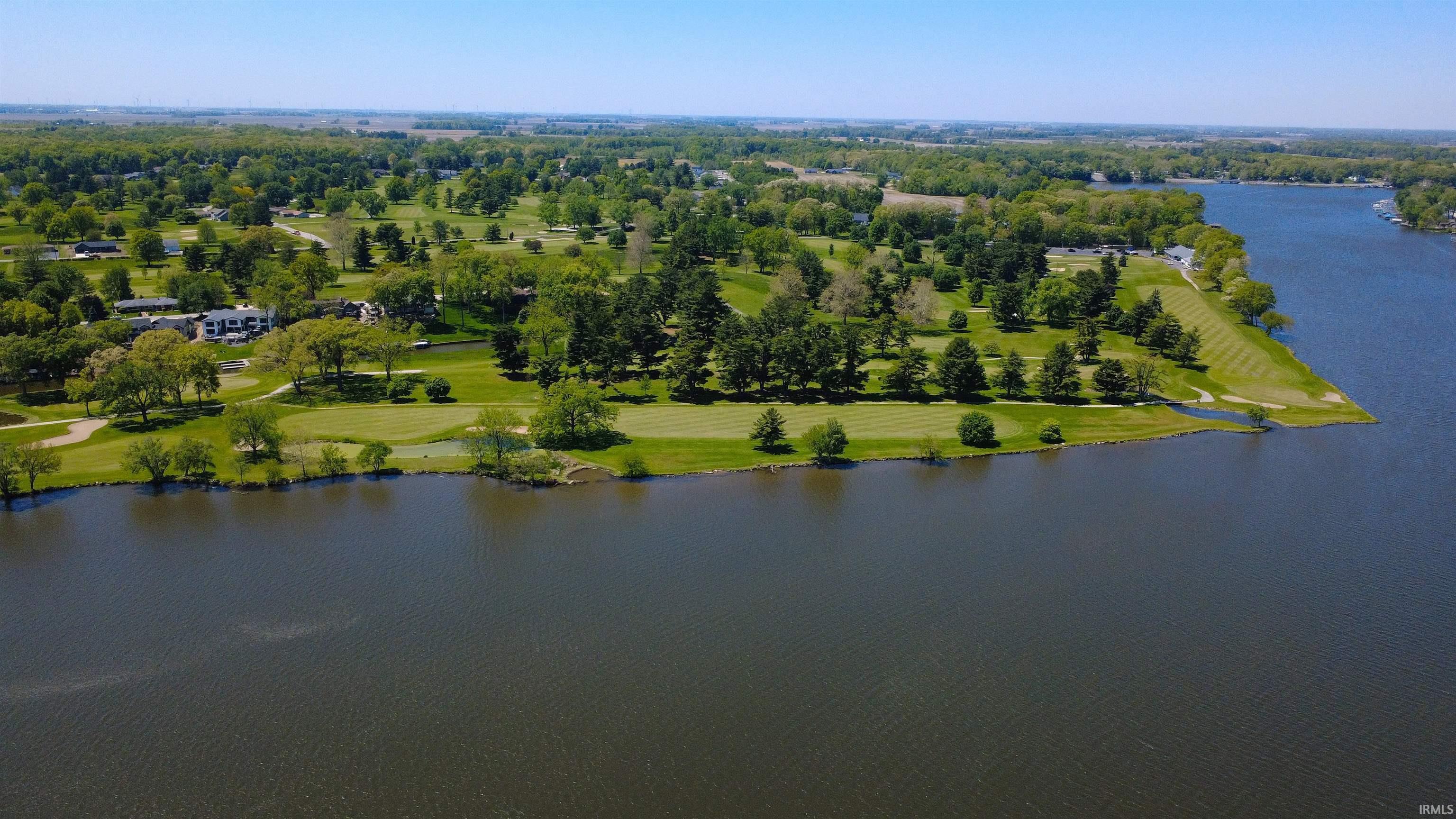 Image 2: Expansive waterfront property featuring a manicured golf course, mature trees, and direct water access, Aerial View