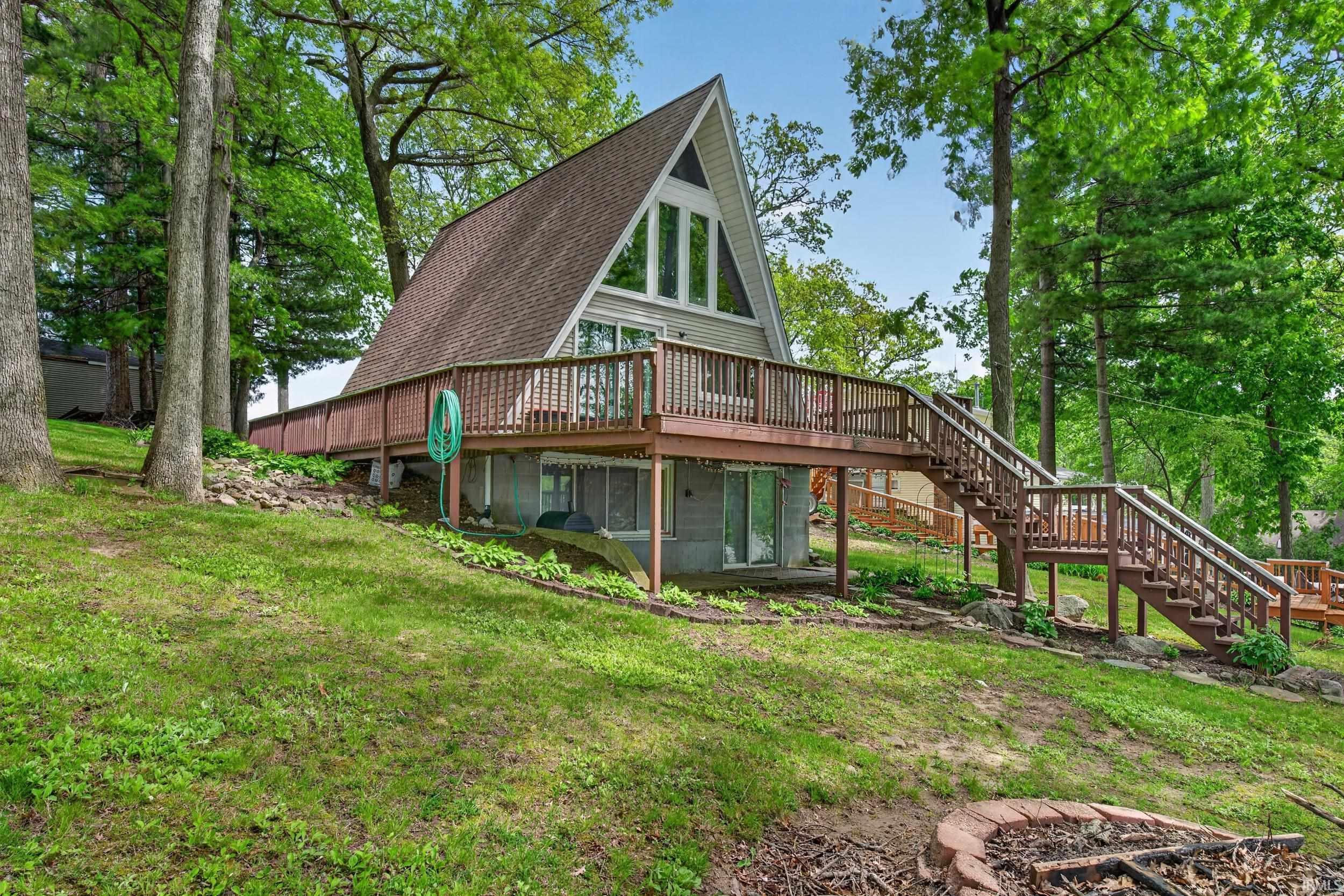 Image 3: A-frame residence with a prominent gabled roofline and a front-facing deck, Lake side Image 3: A-frame residence with a prominent gabled roofline and a front-facing deck, Lake side
