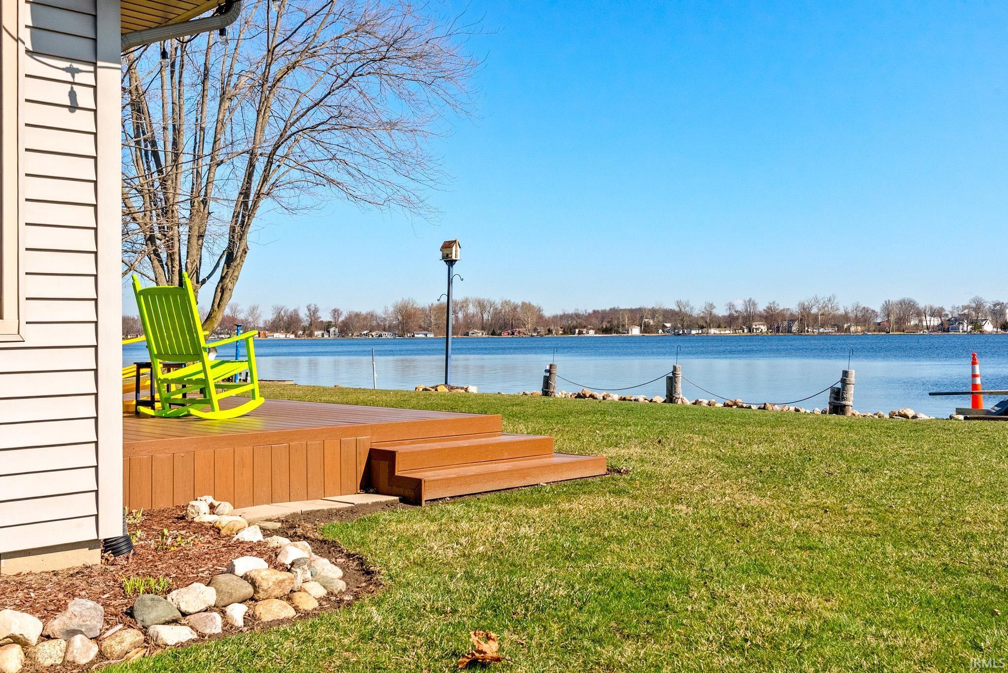 Image 1: View of grassy yard with a deck with water view, Yard Image 1: View of grassy yard with a deck with water view, Yard