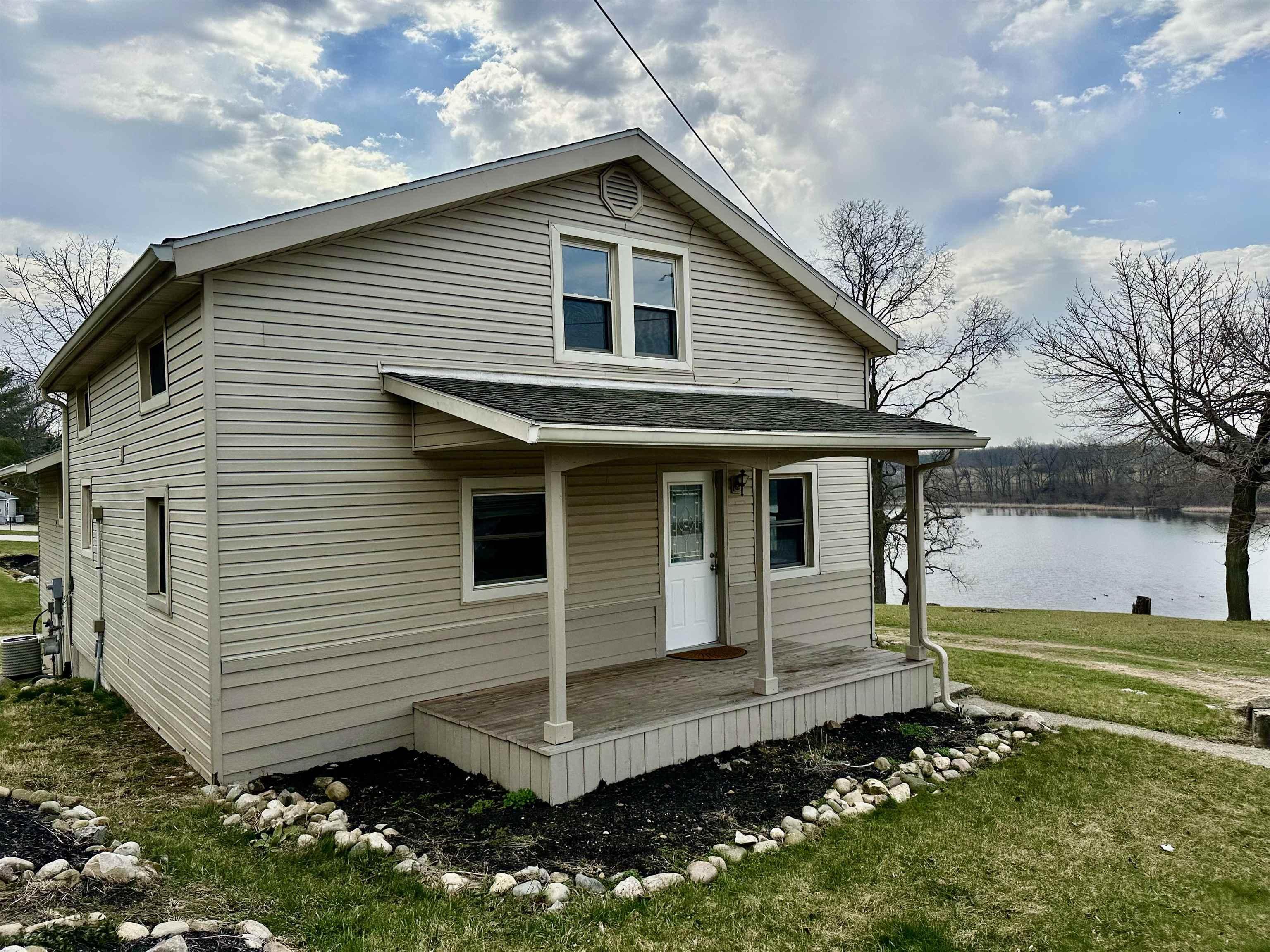 Image 0: View of front of house with a porch, a front yard, a shingled roof, and a water view, Front Of Structure