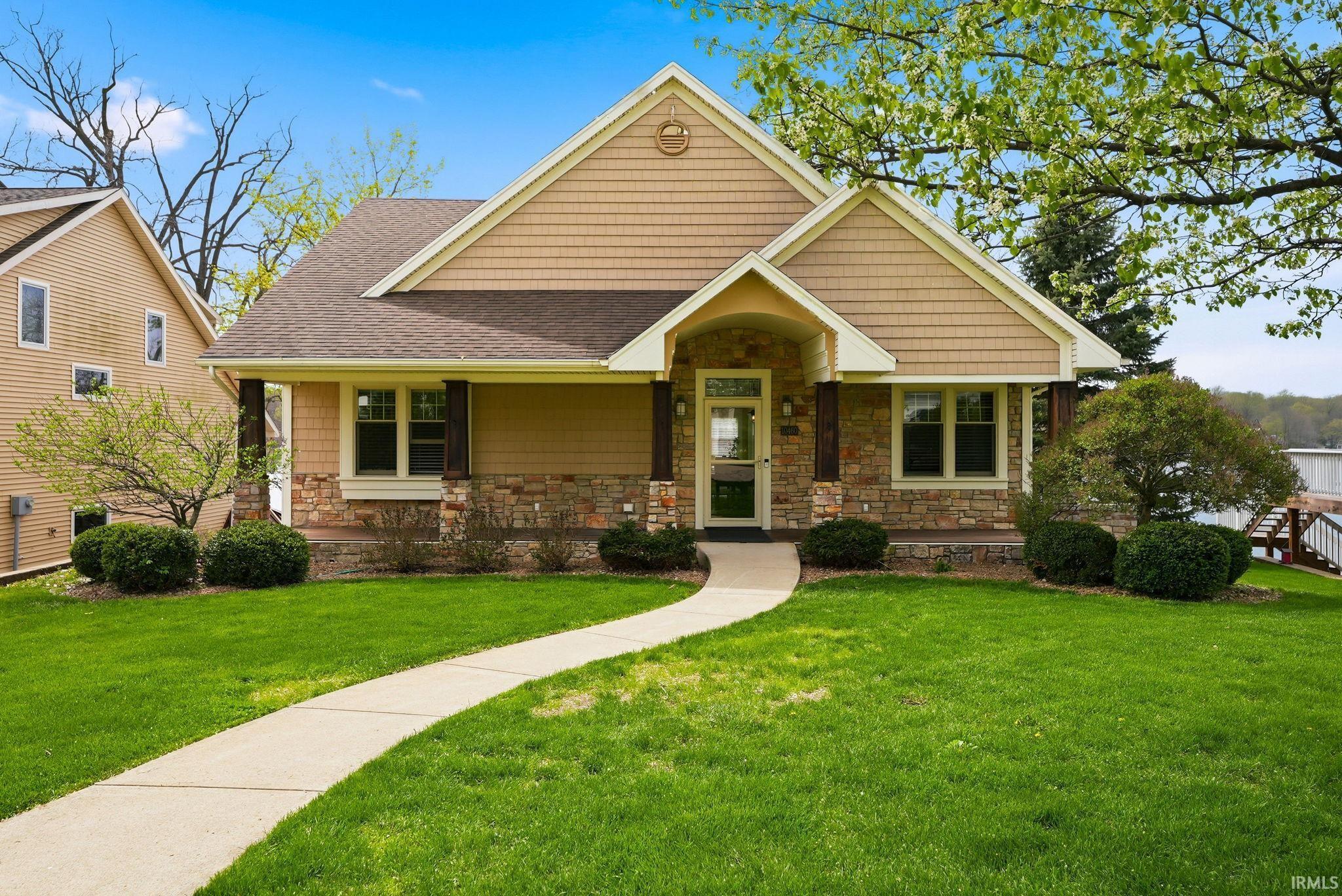 Image 0: Craftsman house with stone siding, a front yard, roof with shingles, and a porch, Front Of Structure