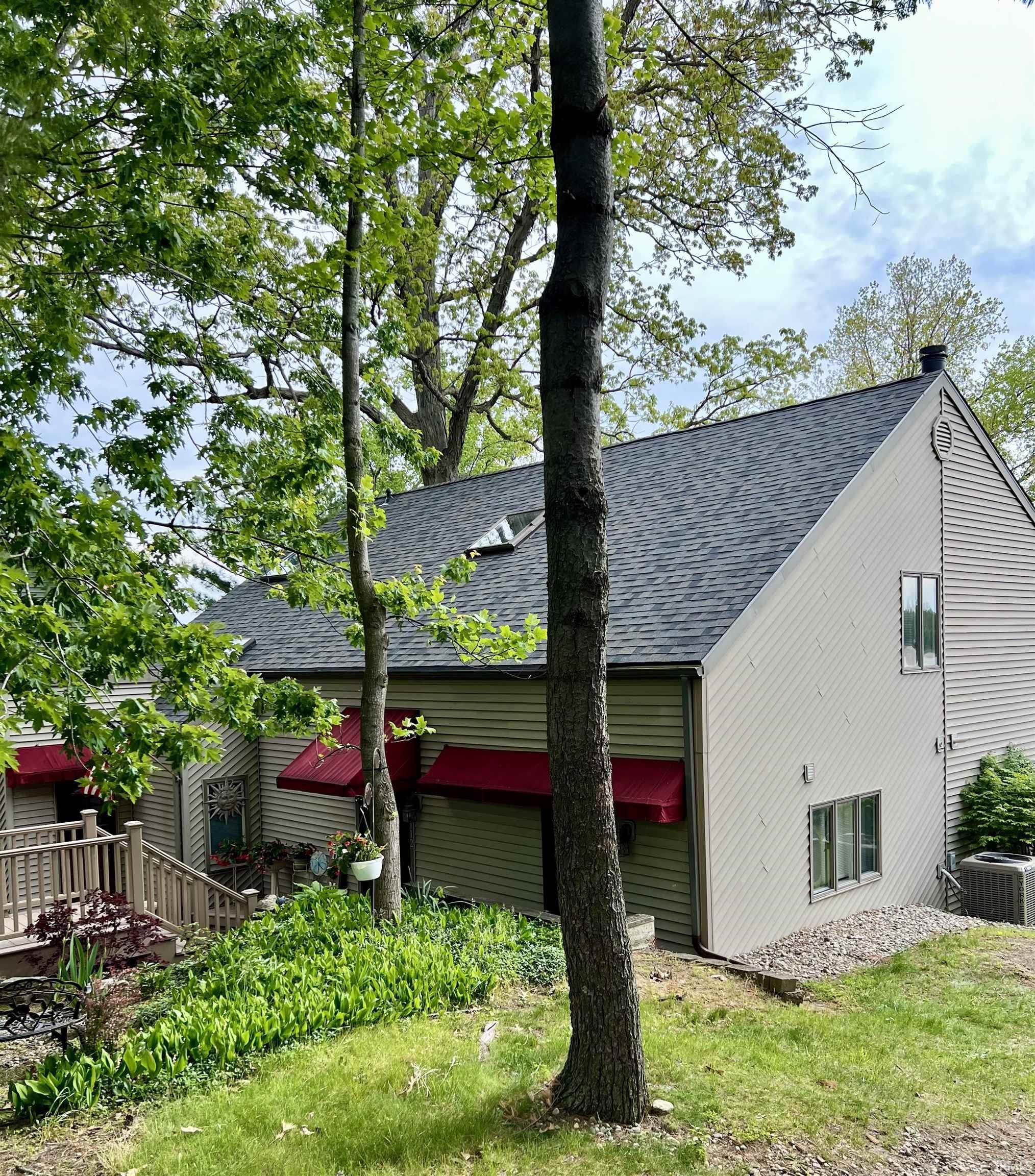 Image 1: Beige horizontal siding exterior with a dark shingle roof featuring a skylight, Side Of Structure Image 1: Beige horizontal siding exterior with a dark shingle roof featuring a skylight, Side Of Structure