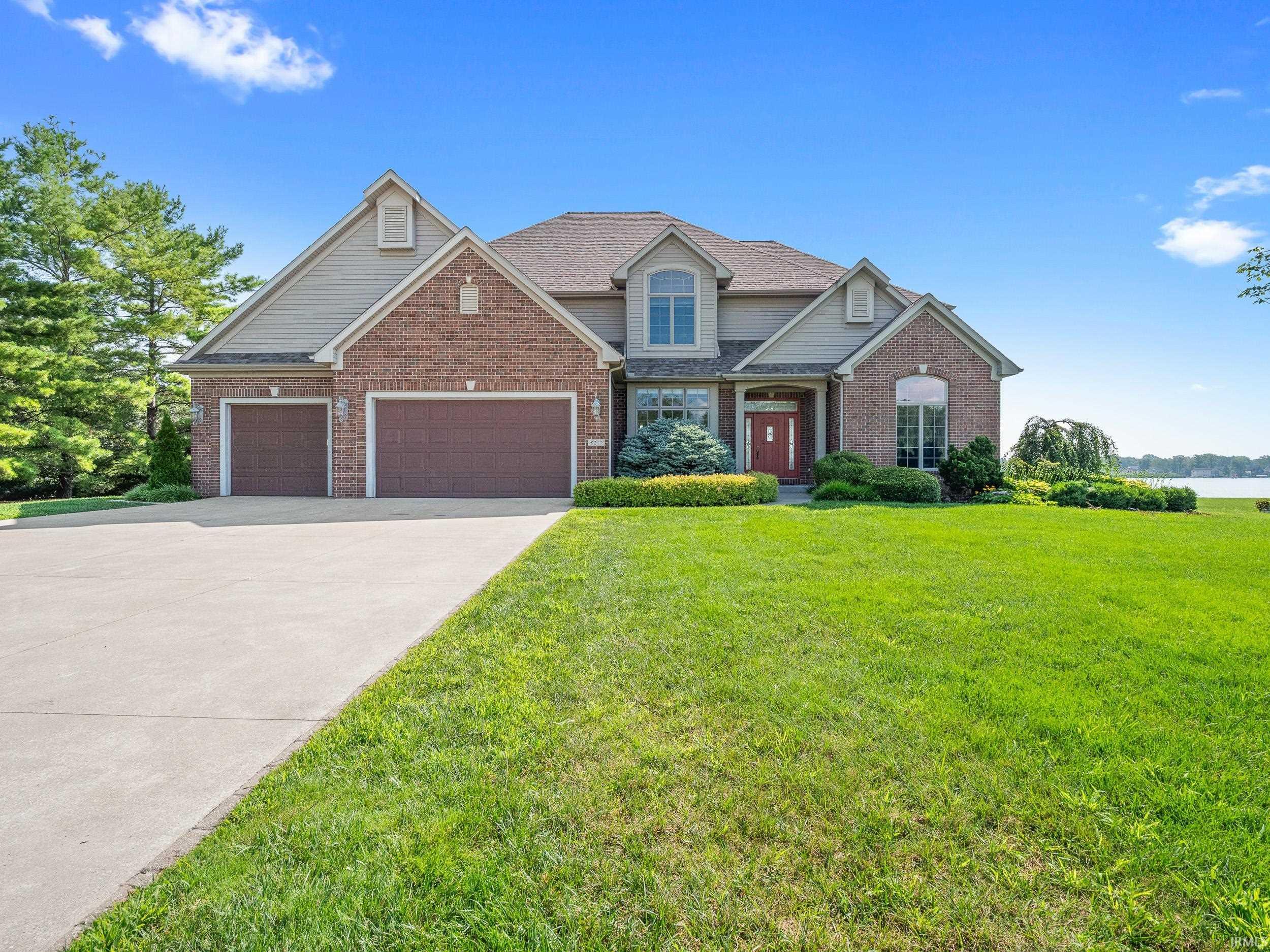Image 3: View of front of home with driveway, a front lawn, brick siding, and an attached garage, Front Of Structure