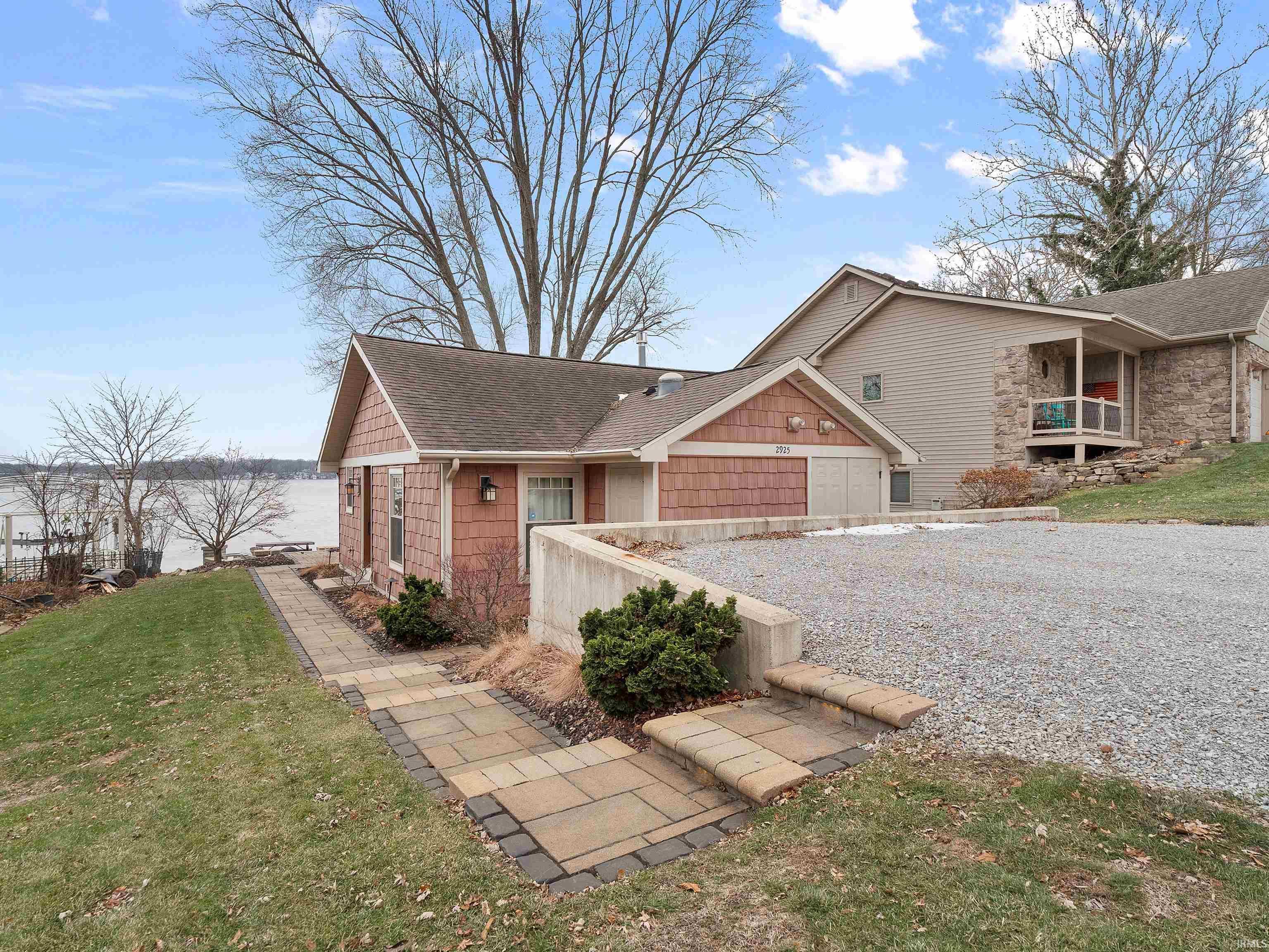 Image 2: View of front of home with a shingled roof, a front yard, and gravel driveway, Front Of Structure
