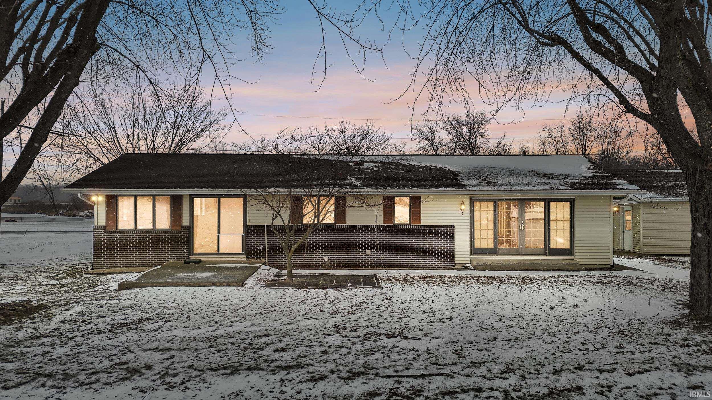 Image 1: View of front of property with brick siding and a shingled roof, Front Of Structure