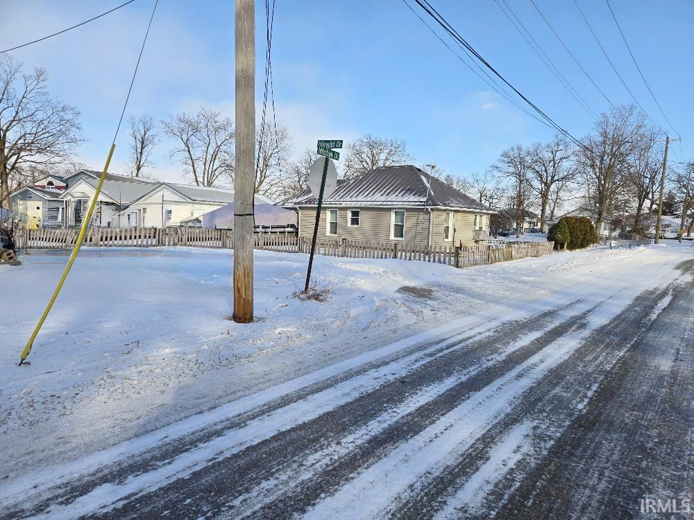 Image 3: View of front of property featuring a residential view, a metal roof, and a chimney, Front Of Structure