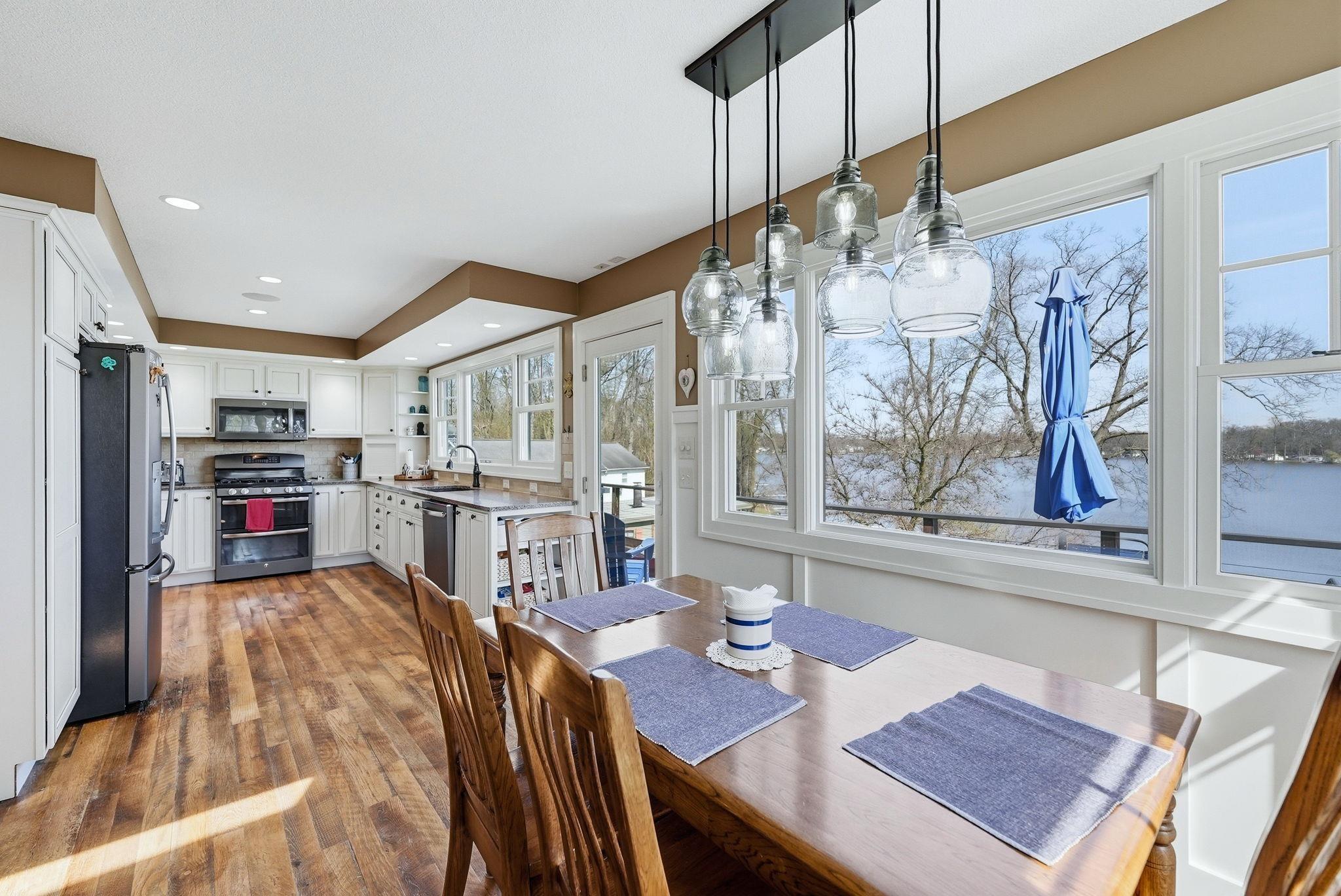 Image 2: Open-concept dining area with wood-finish flooring and a multi-light pendant fixture, Dining Area