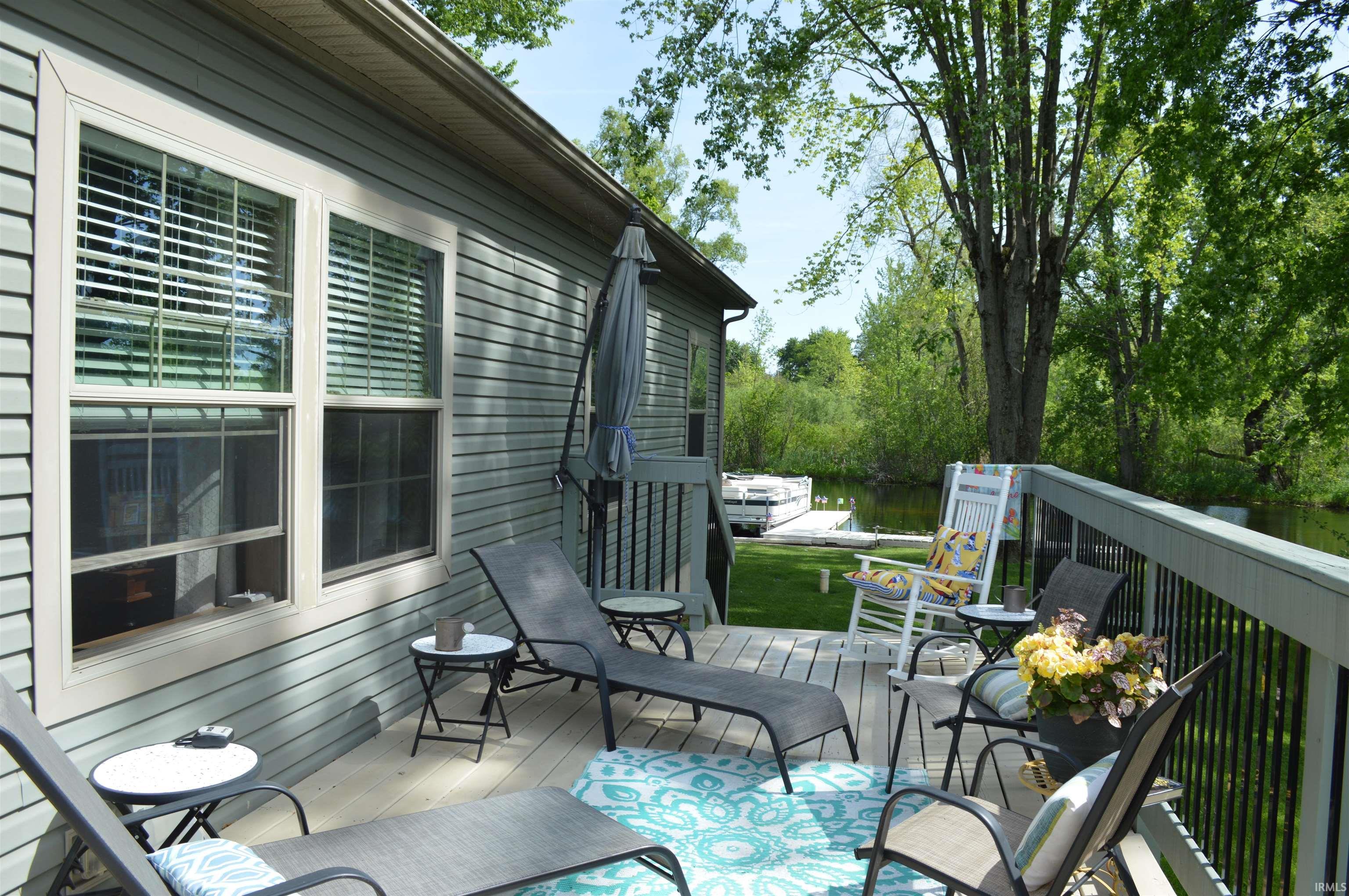 Image 2: Exterior wood-finish deck with black metal railings, Deck Image 2: Exterior wood-finish deck with black metal railings, Deck