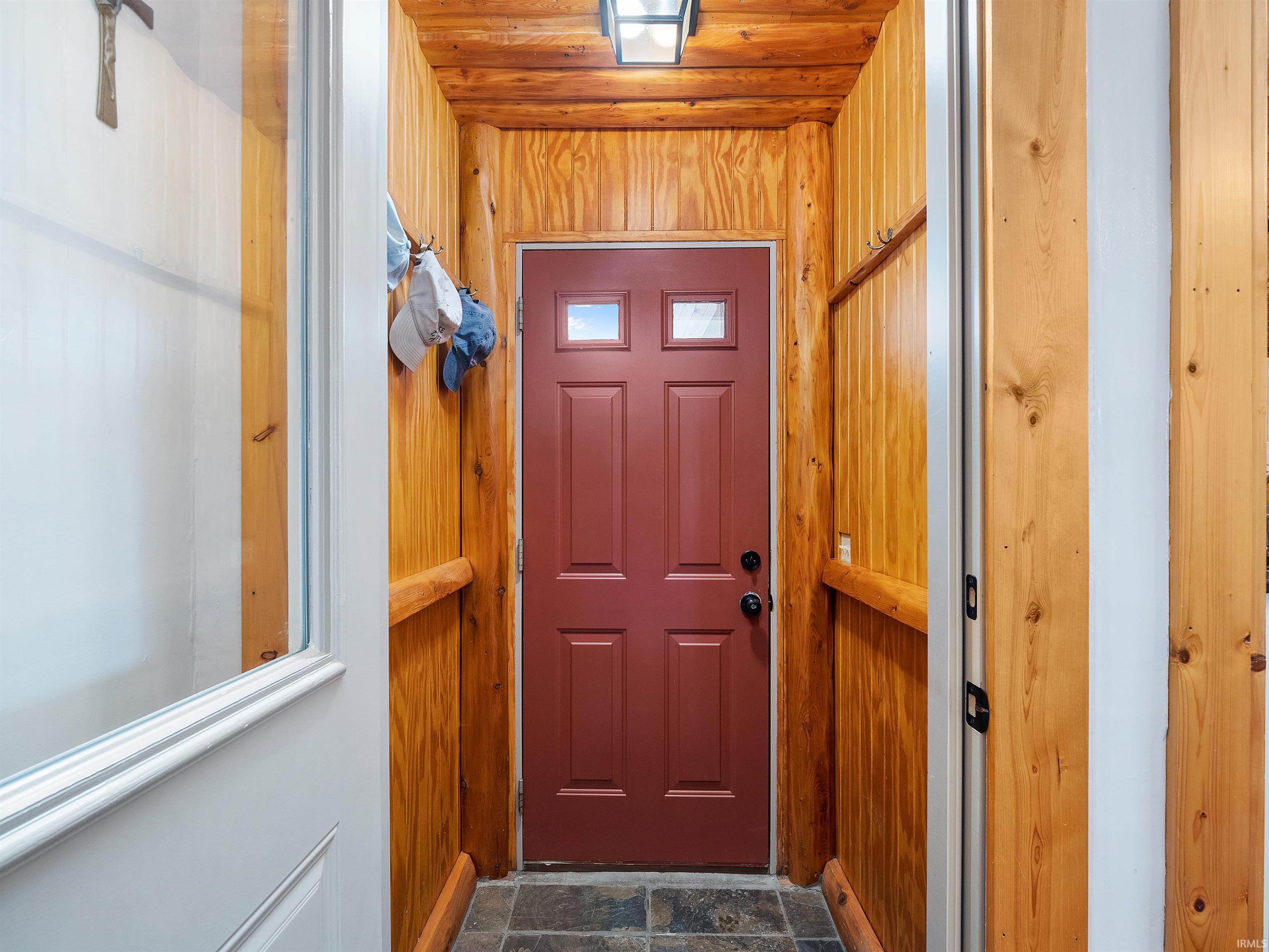 Image 3: Doorway to outside with stone finish floors, wooden walls, and wood ceiling, Entry Image 3: Doorway to outside with stone finish floors, wooden walls, and wood ceiling, Entry