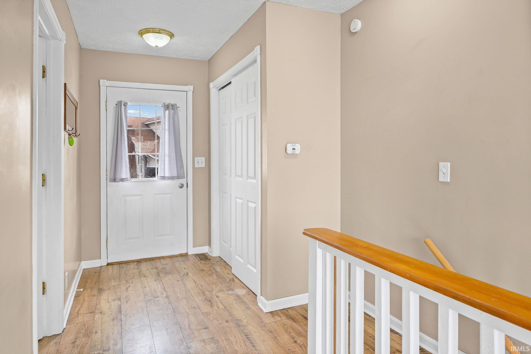 Image 3: Entryway with hardwood / wood-style floors and a textured ceiling, Entry
