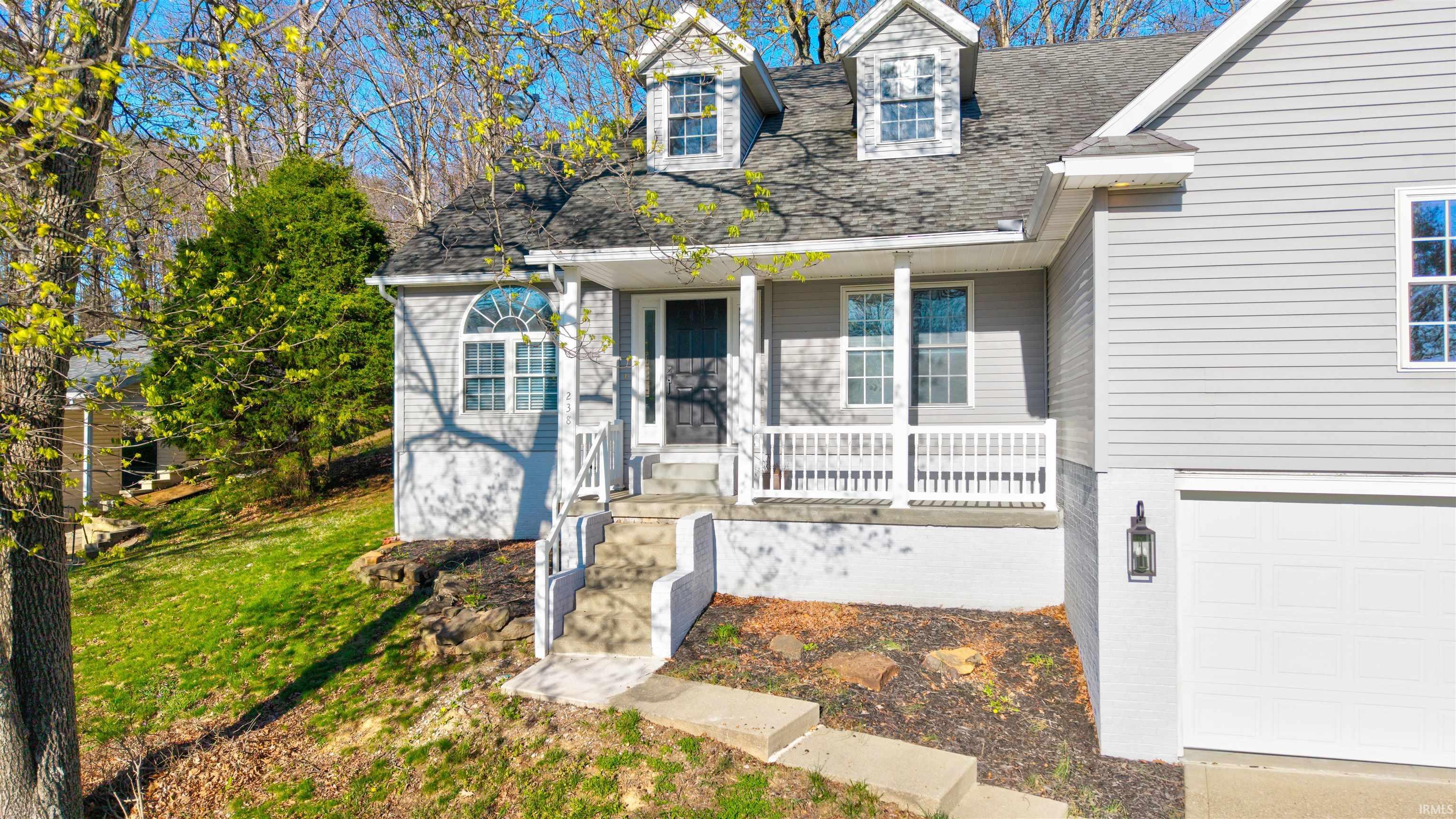 Image 2: View of front facade featuring a porch, a shingled roof, an attached garage, and a front lawn, Front Of Structure Image 2: View of front facade featuring a porch, a shingled roof, an attached garage, and a front lawn, Front Of Structure