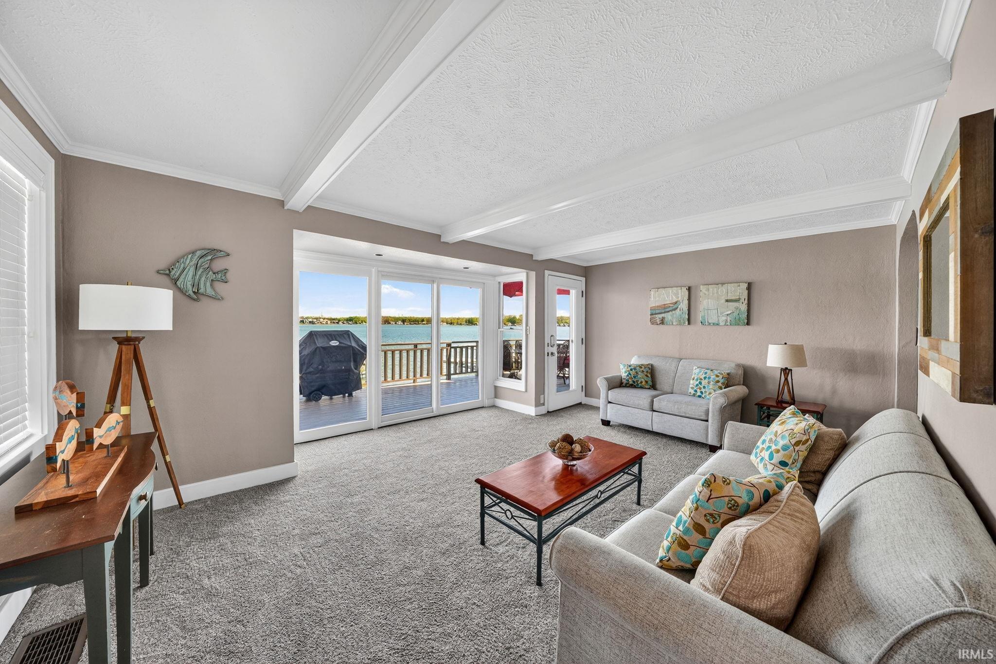 Image 2: Sliding glass doors opening to a waterfront deck, providing abundant natural light, Living Room