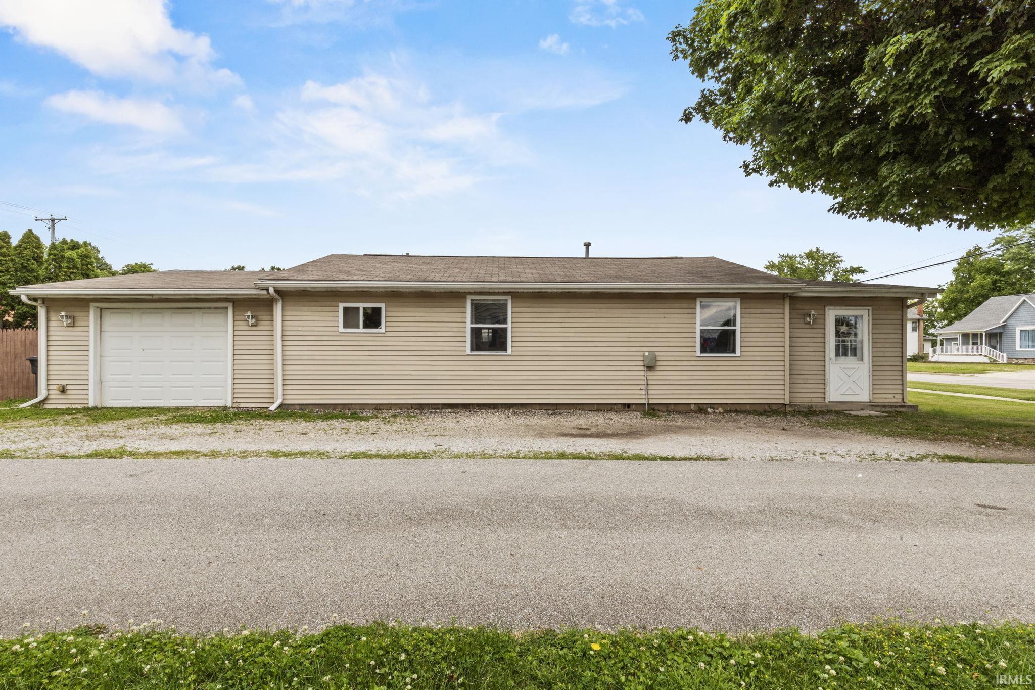 Image 1: Single-story residence featuring light-colored siding, an attached garage with a white door, multiple windows, a white entry door, and a brown shingle roof, Front Of Structure Image 1: Single-story residence featuring light-colored siding, an attached garage with a white door, multiple windows, a white entry door, and a brown shingle roof, Front Of Structure