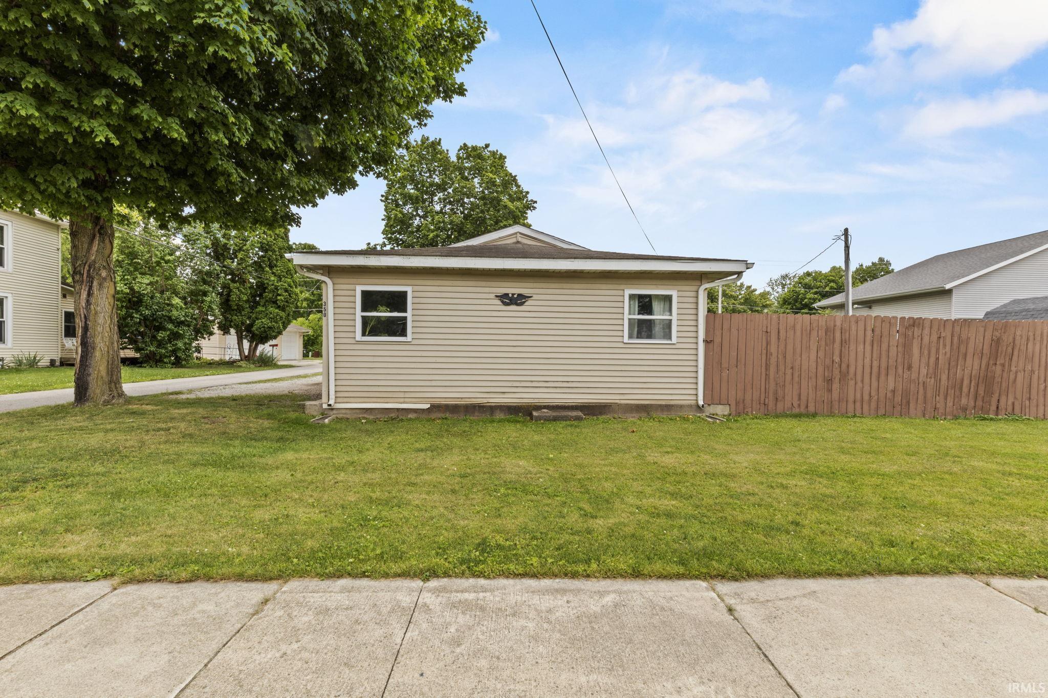 Image 3: Detached structure with tan horizontal siding, white trim windows, and a black shingle roof, Side Of Structure Image 3: Detached structure with tan horizontal siding, white trim windows, and a black shingle roof, Side Of Structure