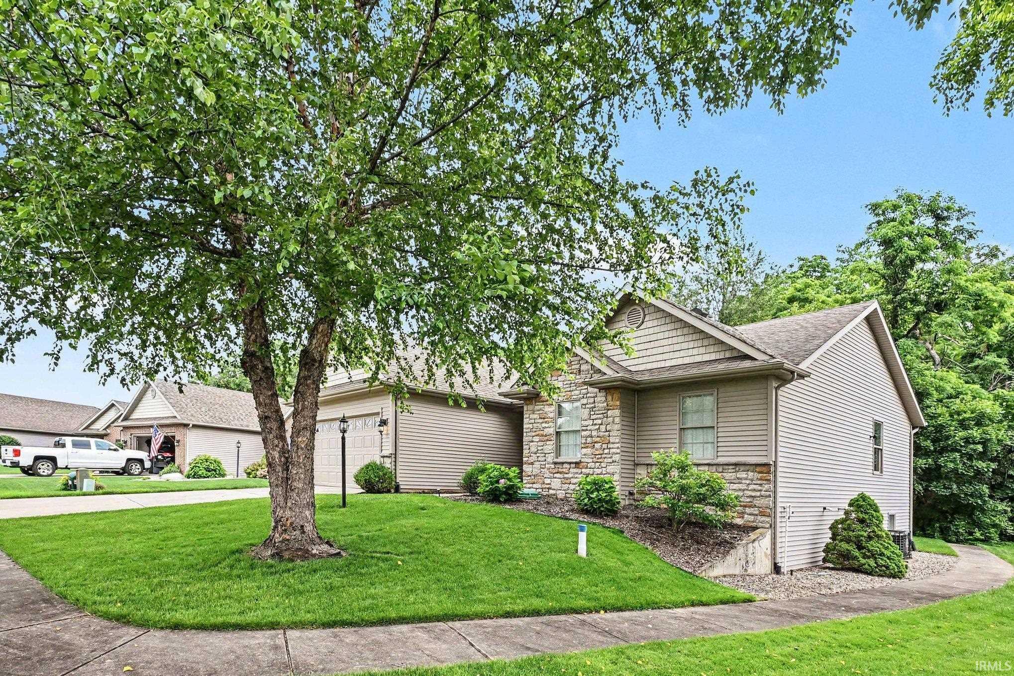 Image 2: Exterior property featuring stone veneer accents, horizontal siding, a gabled roof, a two-car garage, and a concrete driveway, Front Of Structure Image 2: Exterior property featuring stone veneer accents, horizontal siding, a gabled roof, a two-car garage, and a concrete driveway, Front Of Structure
