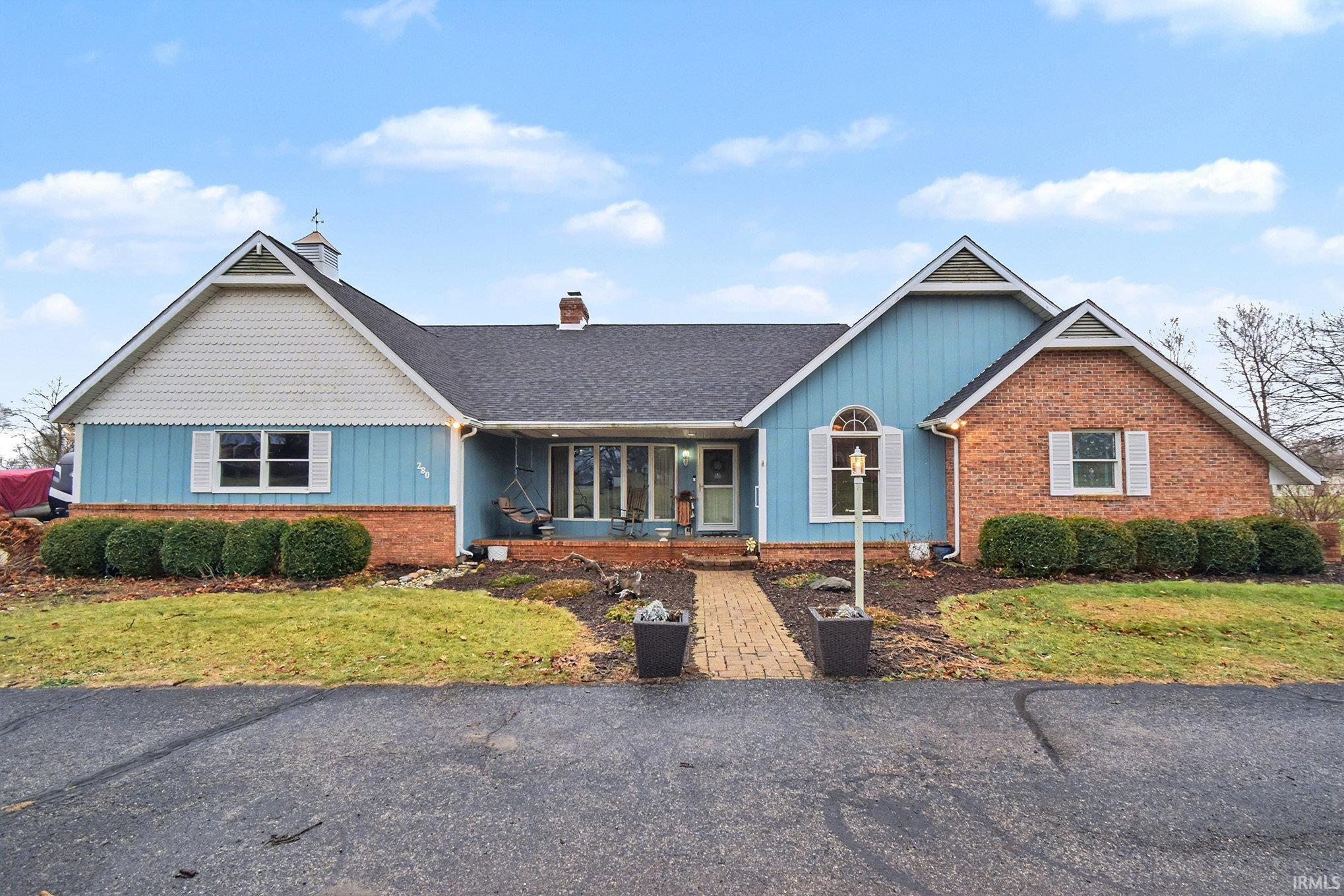 Image 0: Single story home with a porch, a chimney, a front lawn, and board and batten siding, Front Of Structure