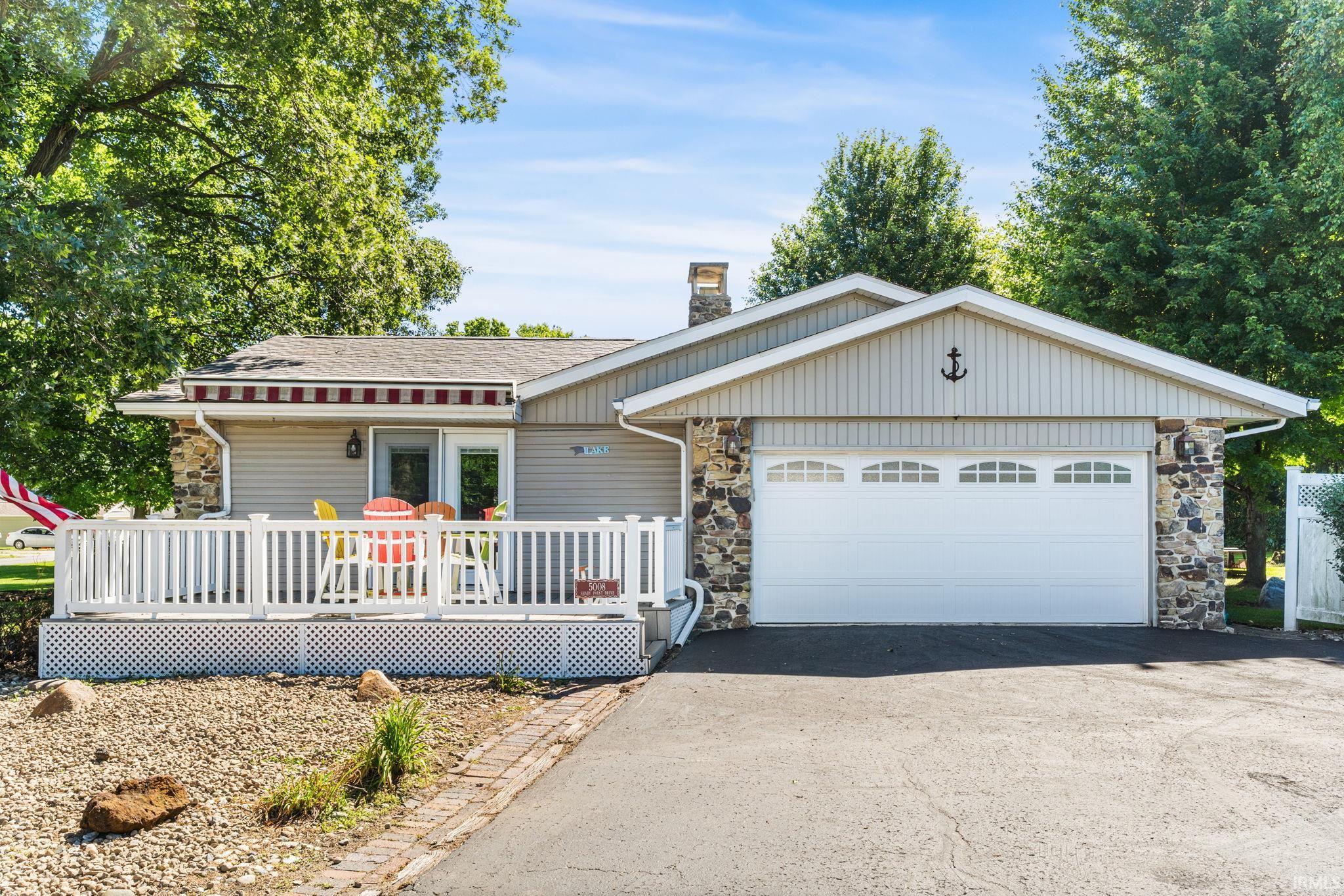 Image 0: Ranch-style exterior with stone veneer accents and light-colored siding, Front Of Structure