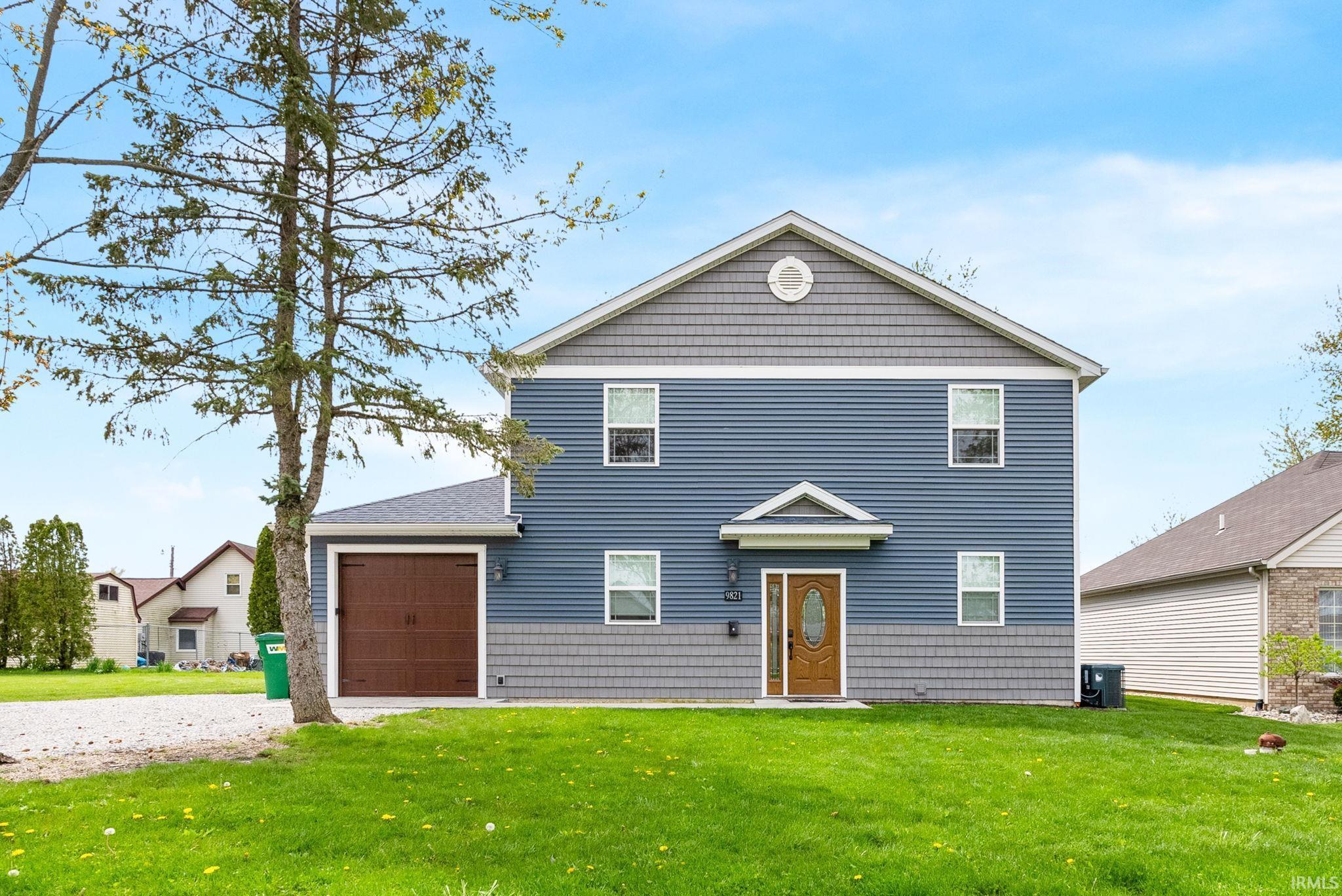 Image 3: View of front of home with a front yard, a garage, and gravel driveway, Front Of Structure