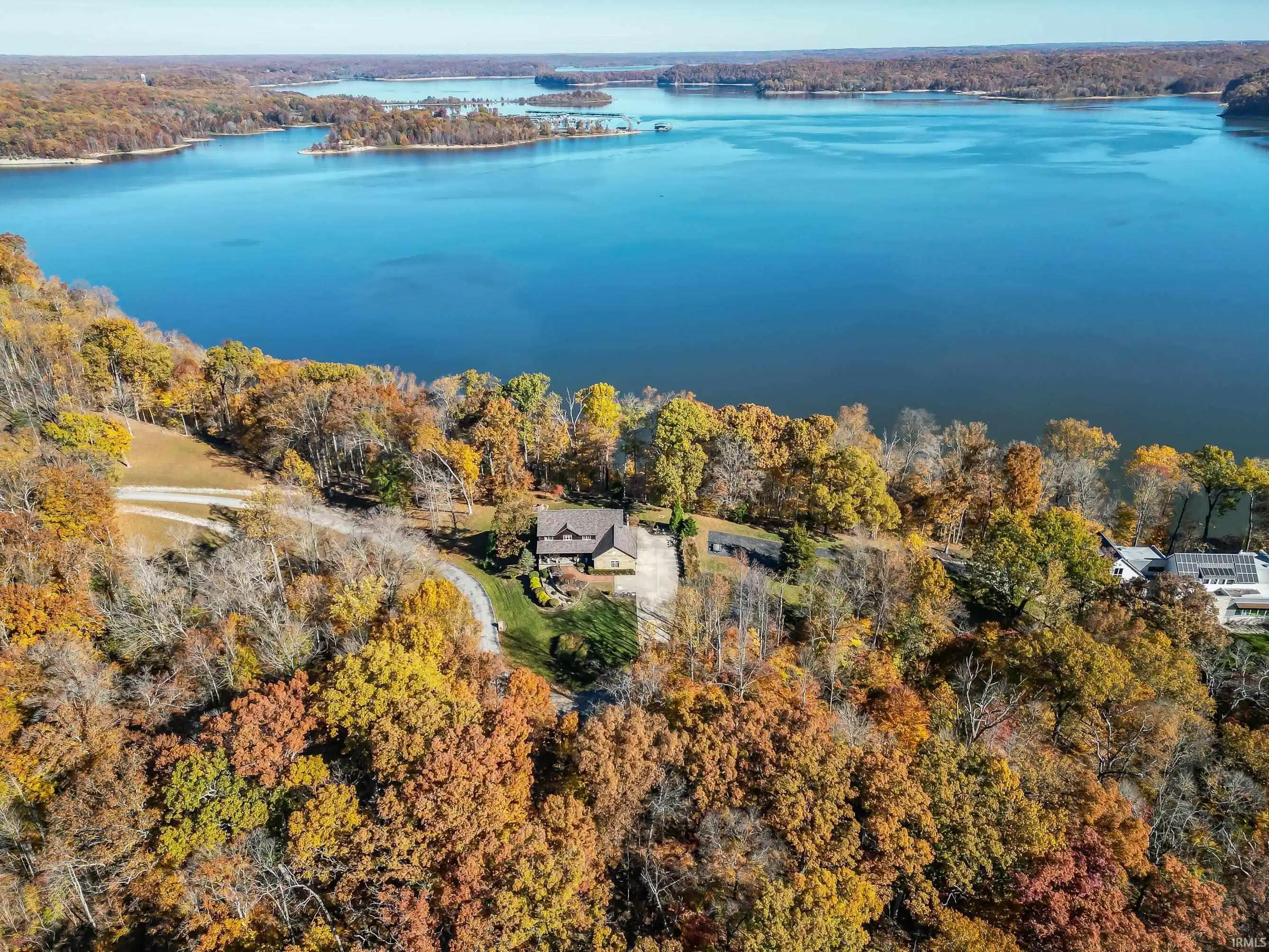 Image 0: Waterfront residence surrounded by mature deciduous trees, Aerial View Image 0: Waterfront residence surrounded by mature deciduous trees, Aerial View