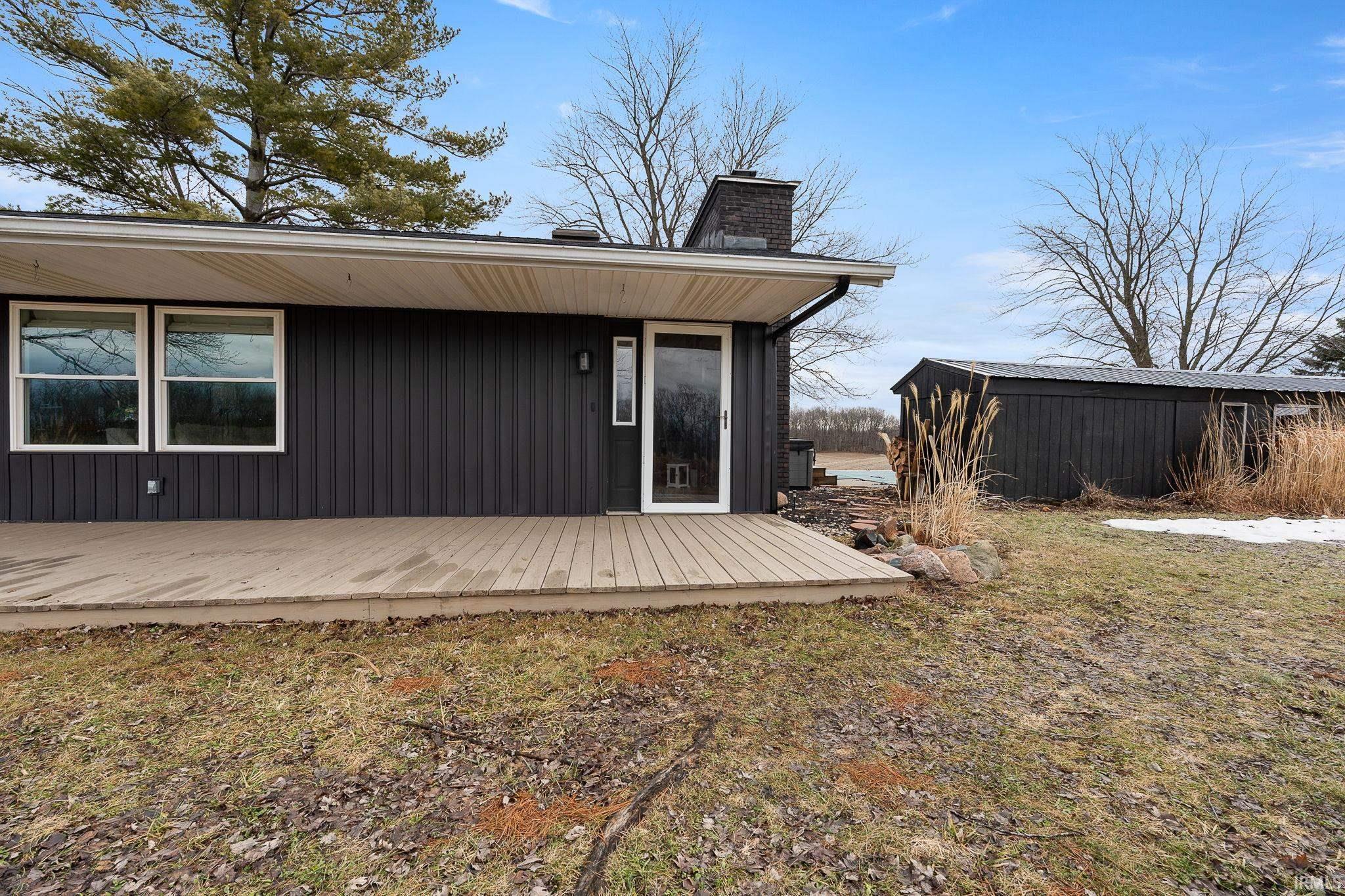 Image 2: Rear view of house featuring a deck and a chimney, Back Of Structure Image 2: Rear view of house featuring a deck and a chimney, Back Of Structure