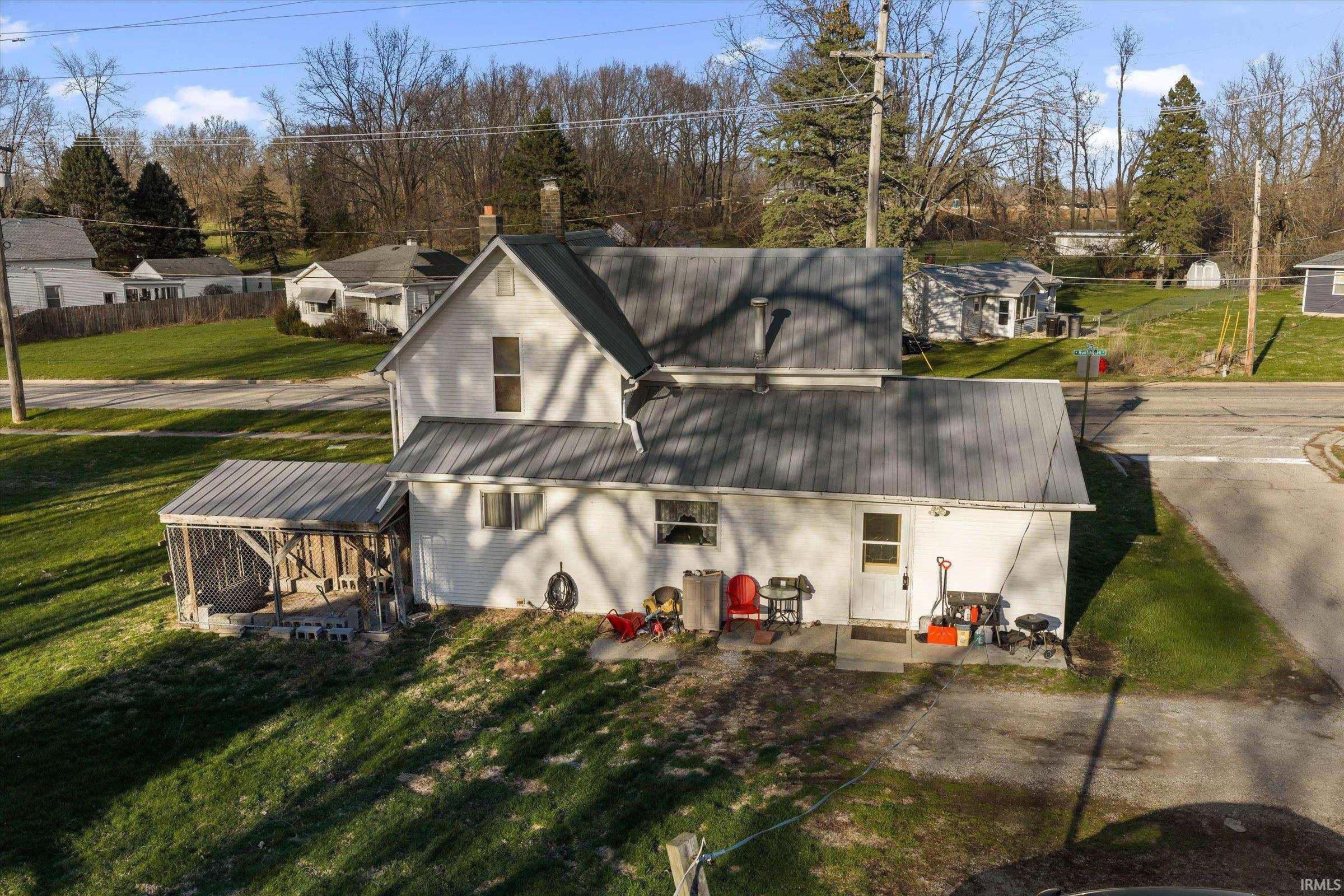 Image 1: Rear view of property with a lawn, a patio area, a chimney, and a residential view, Back Of Structure Image 1: Rear view of property with a lawn, a patio area, a chimney, and a residential view, Back Of Structure