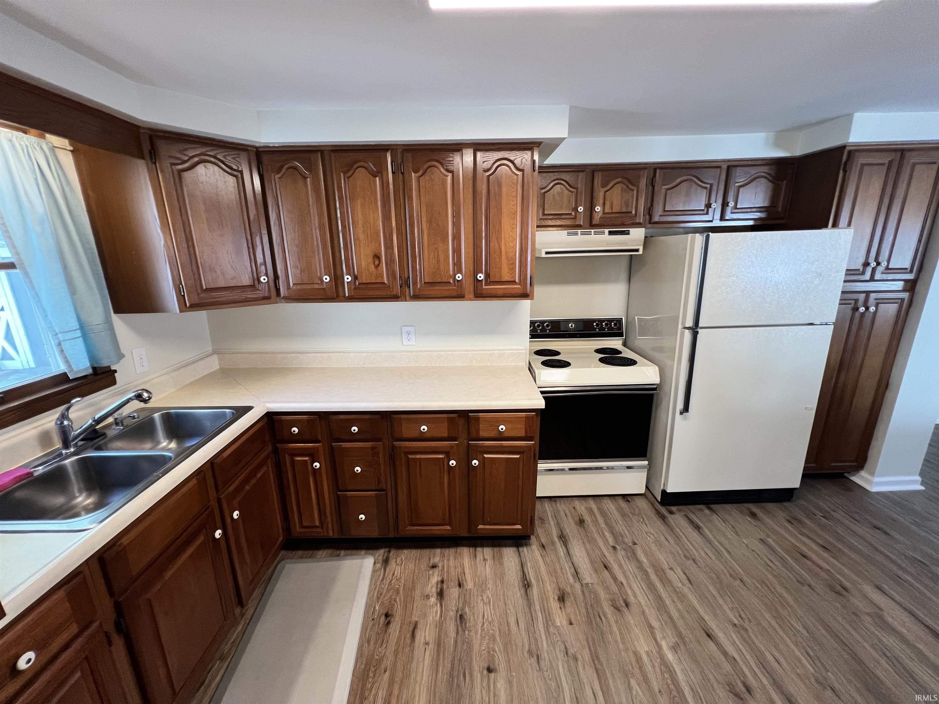 Image 2: Kitchen featuring wood-finish cabinetry, solid surface countertops, and wood-finish flooring, Kitchen Image 2: Kitchen featuring wood-finish cabinetry, solid surface countertops, and wood-finish flooring, Kitchen