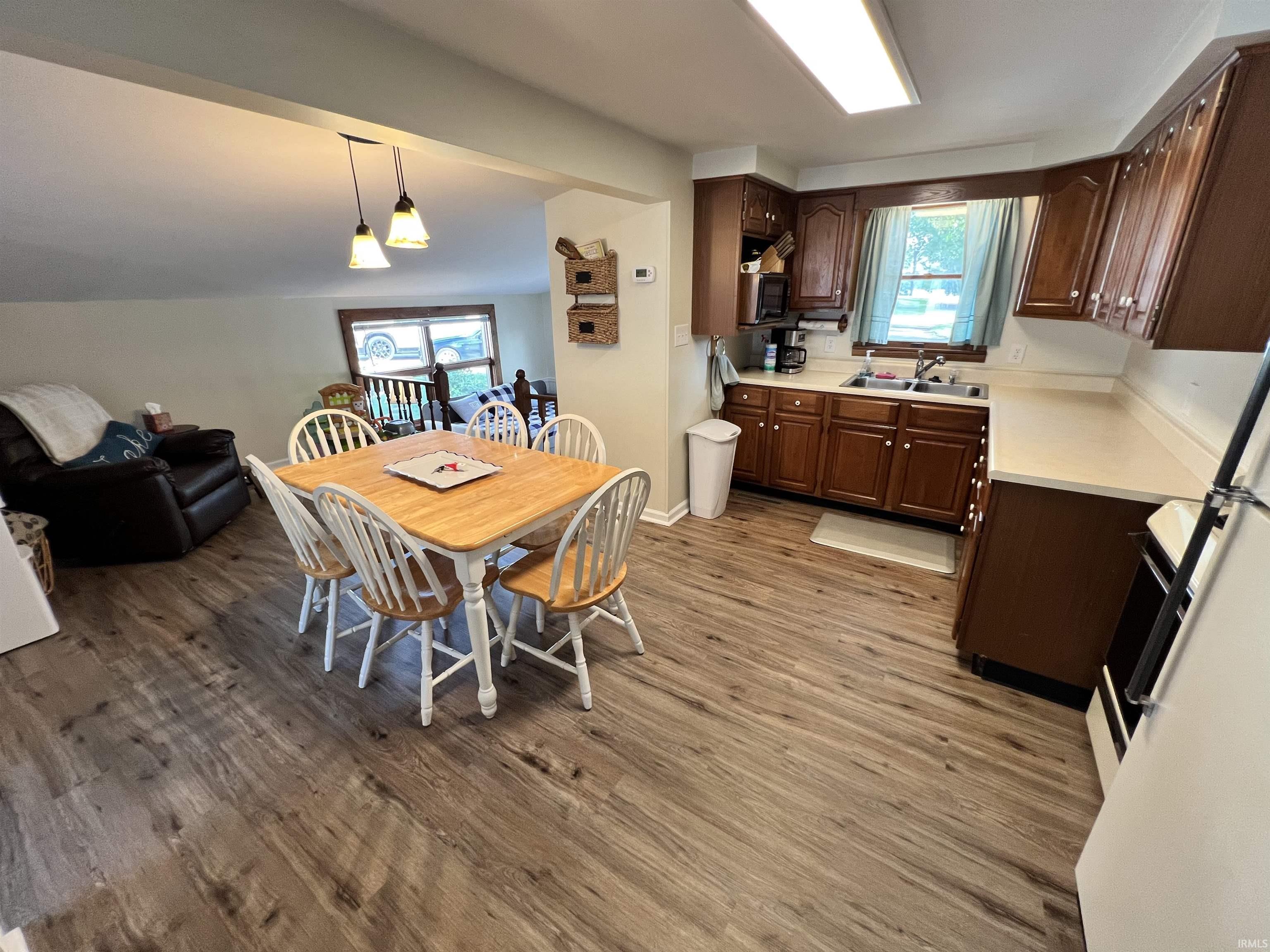 Image 3: Open-concept kitchen and dining area featuring wood-finish flooring, warm wood cabinetry, and a double basin sink, Kitchen Image 3: Open-concept kitchen and dining area featuring wood-finish flooring, warm wood cabinetry, and a double basin sink, Kitchen