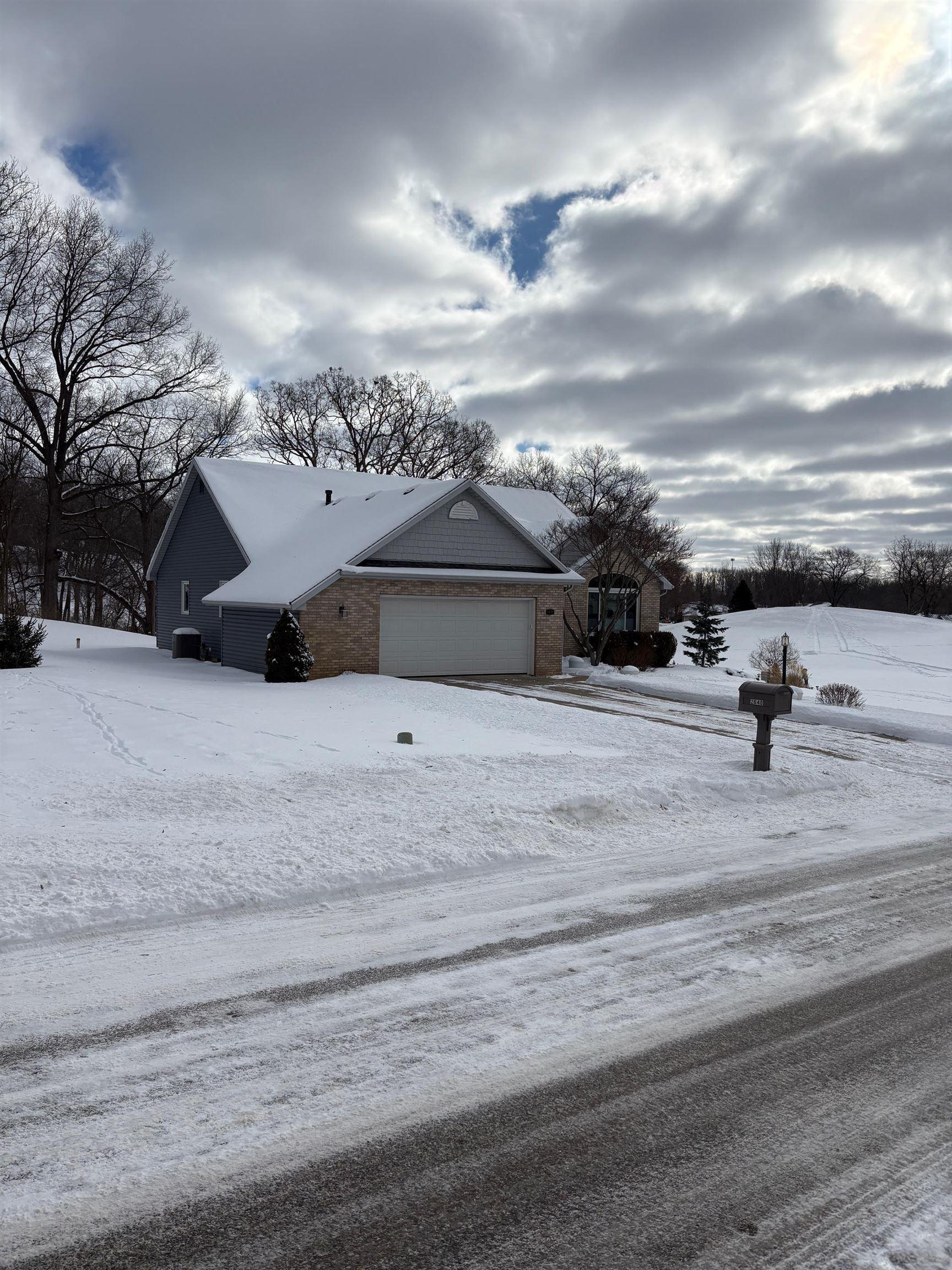 Image 1: Snow covered property featuring an attached garage, Side Of Structure