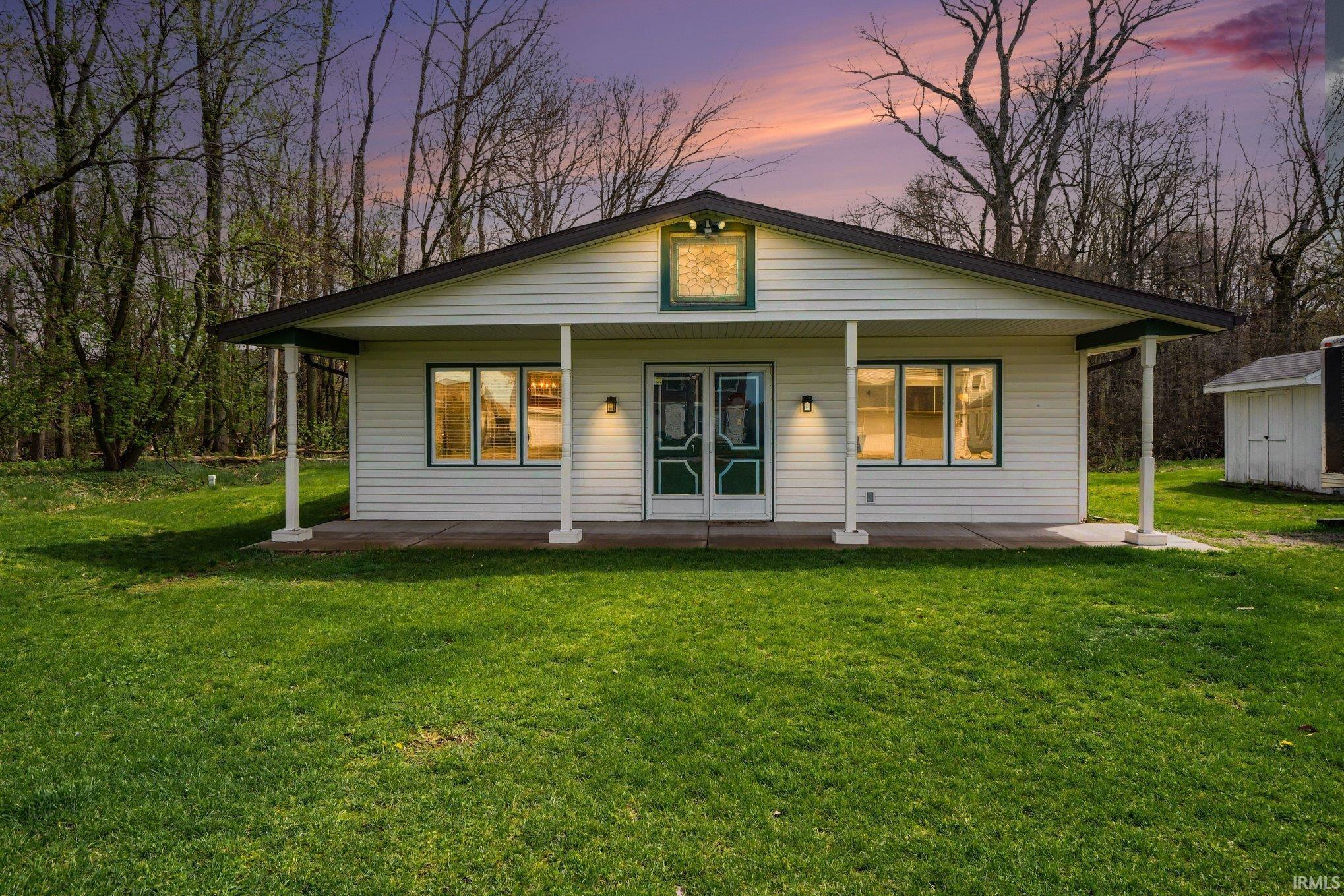 Image 1: Back of property at dusk with a yard and a patio, Back Of Structure