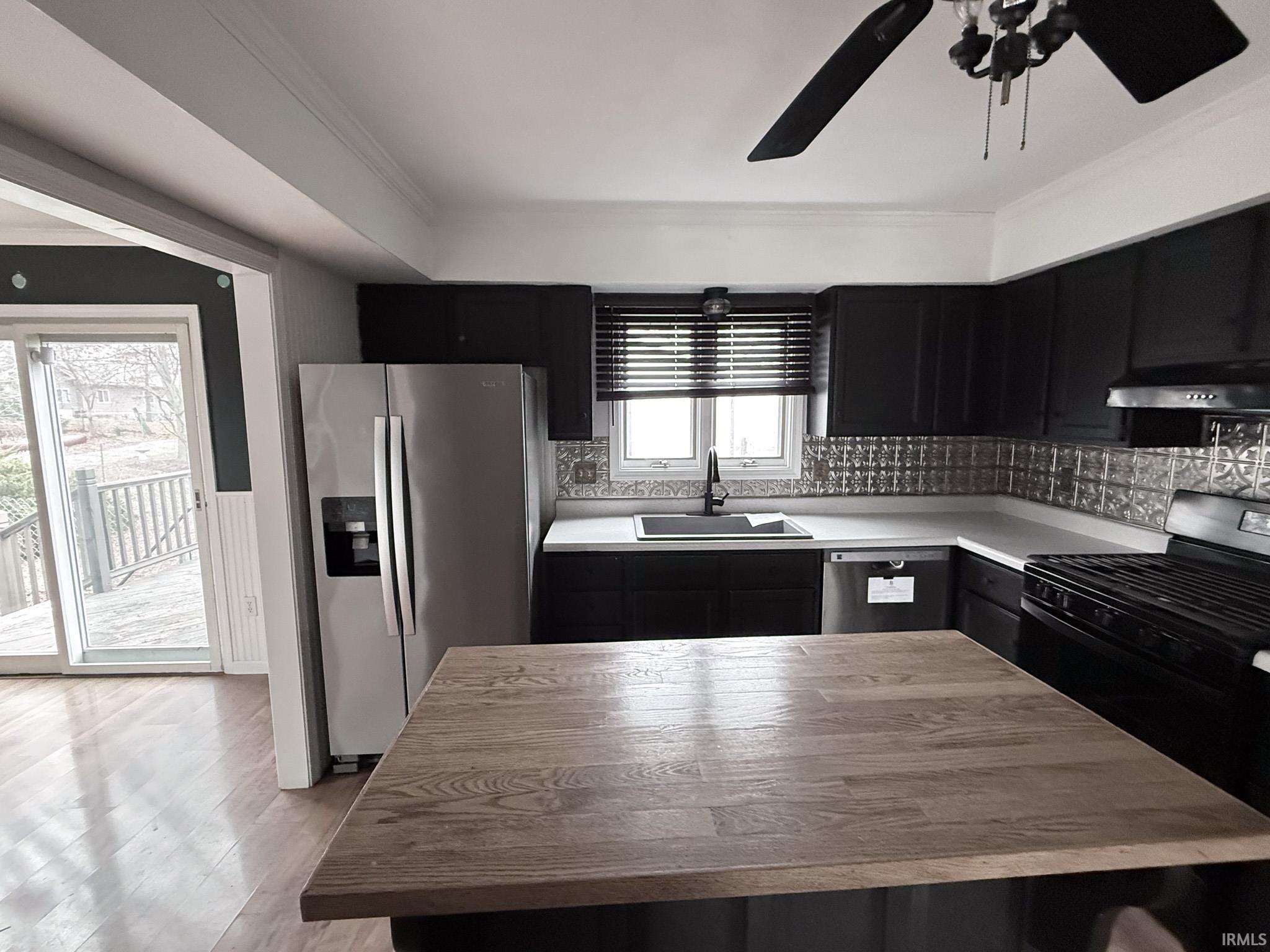 Image 3: Kitchen with dark cabinetry, light countertops, and ornamental molding, Kitchen Image 3: Kitchen with dark cabinetry, light countertops, and ornamental molding, Kitchen