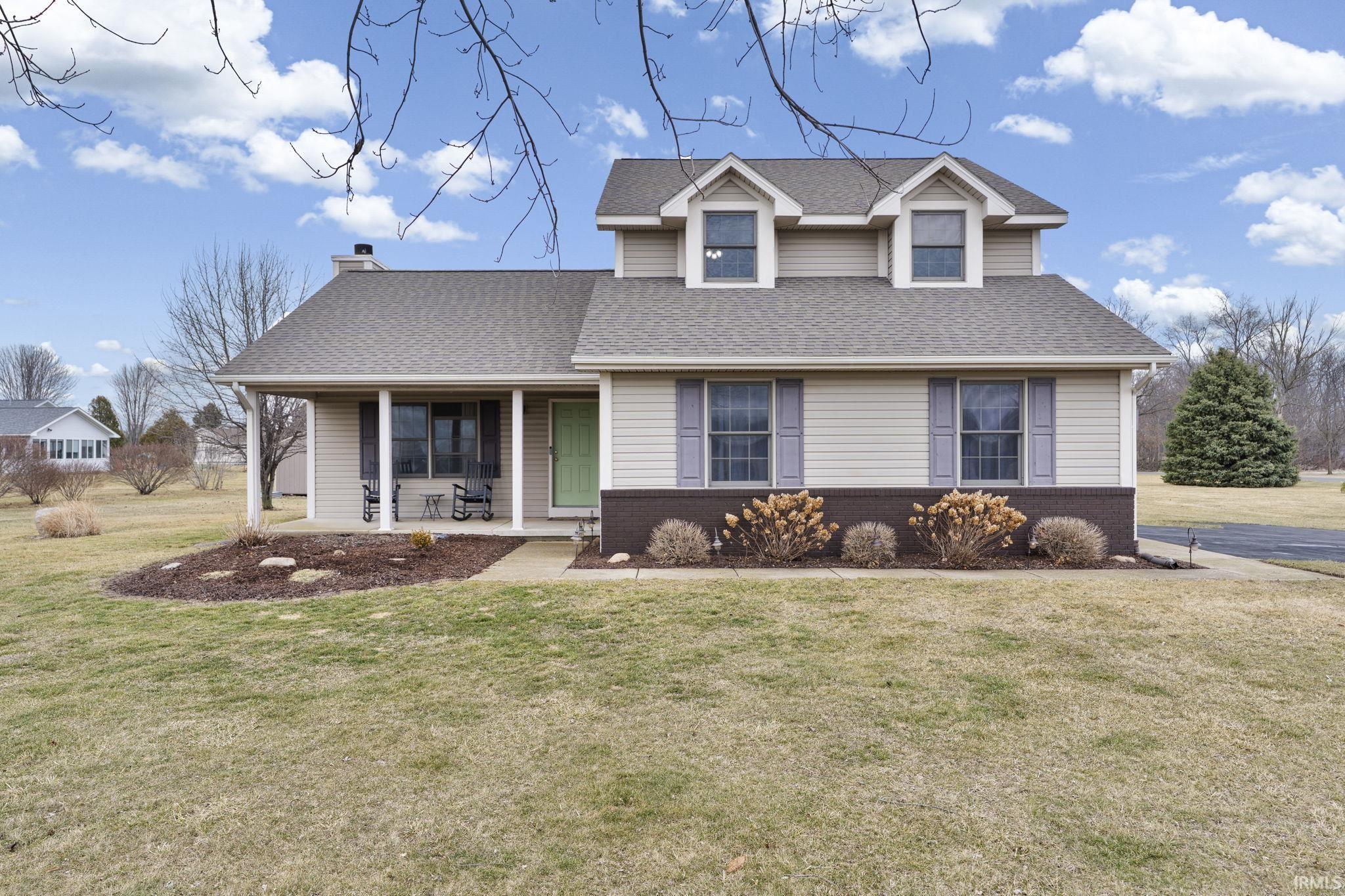 Image 1: View of front of property featuring a porch, a front yard, brick siding, roof with shingles, and a chimney, Front Of Structure