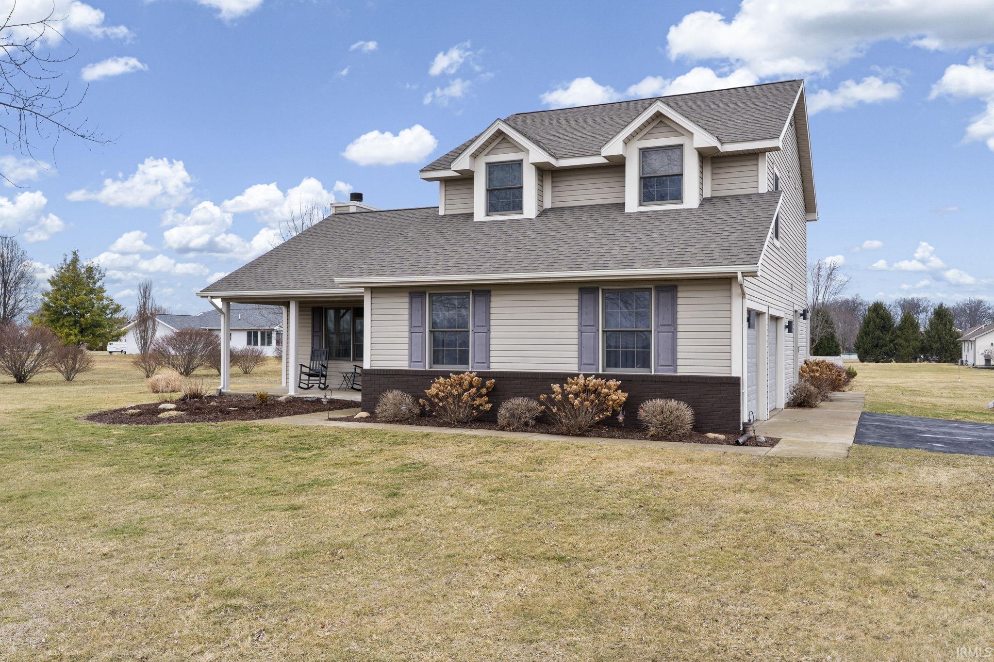 Image 2: View of front facade with a front lawn, brick siding, a shingled roof, and an attached garage, Front Of Structure