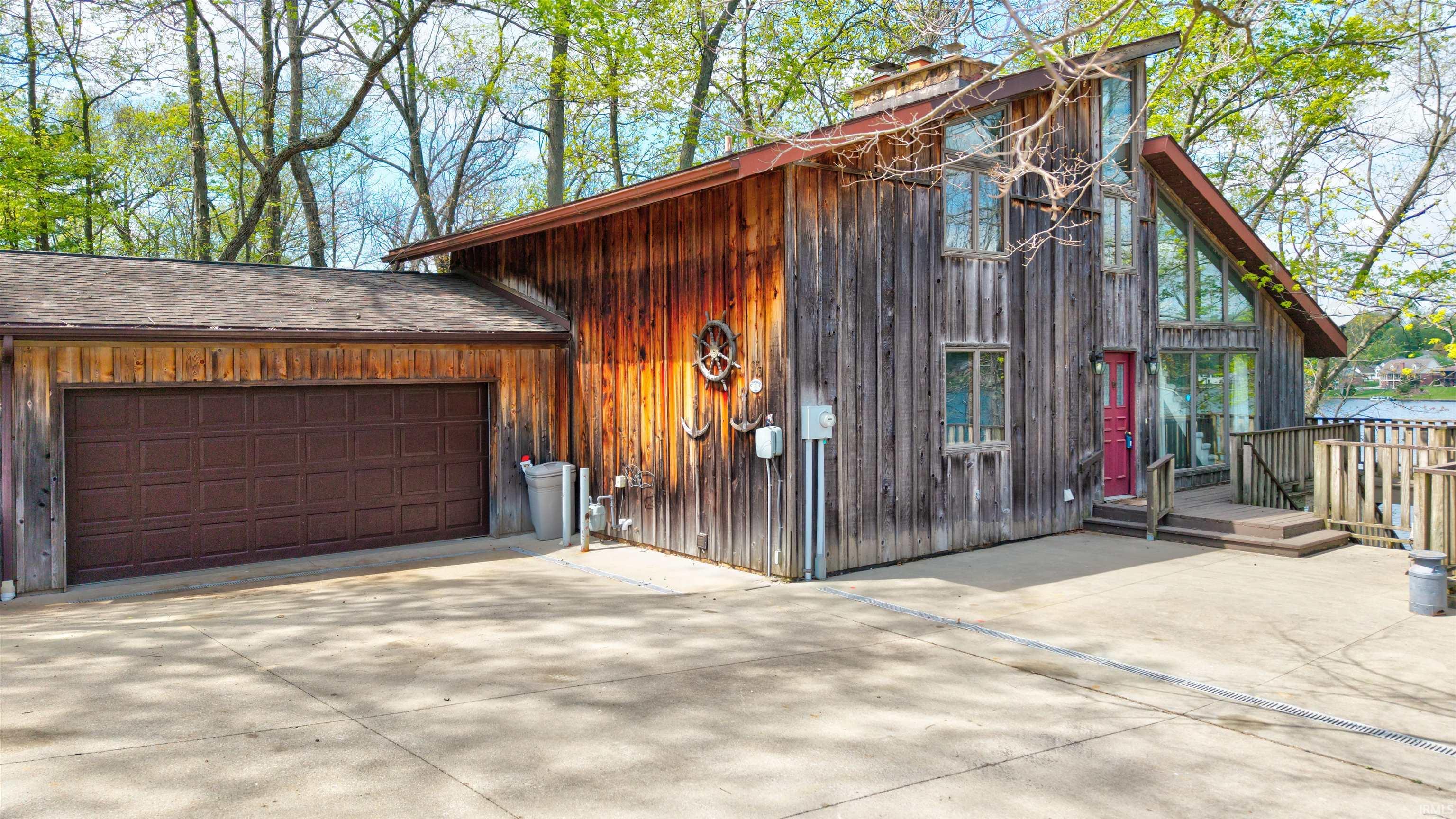 Image 2: View of front of house featuring driveway, a wooden deck, and a garage, Front Of Structure Image 2: View of front of house featuring driveway, a wooden deck, and a garage, Front Of Structure