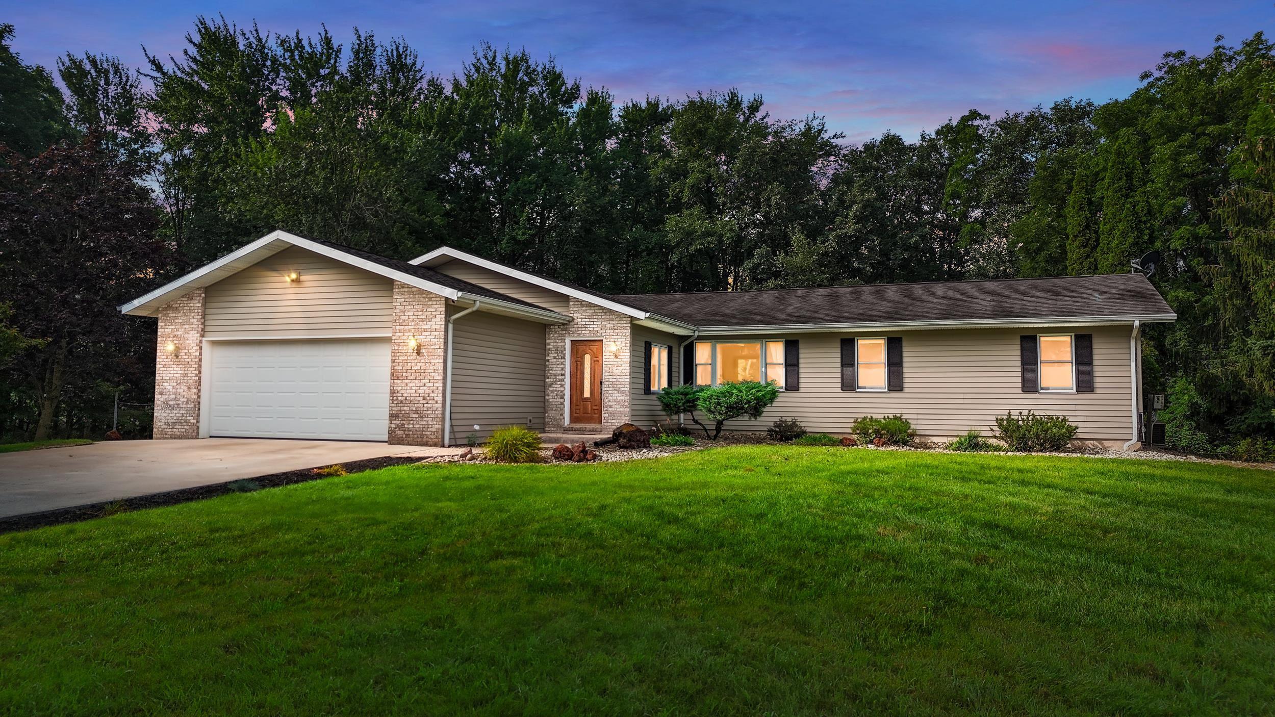 Image 2: Ranch-style residence featuring a brick facade accent, horizontal siding, and a two-car garage, Front Of Structure
