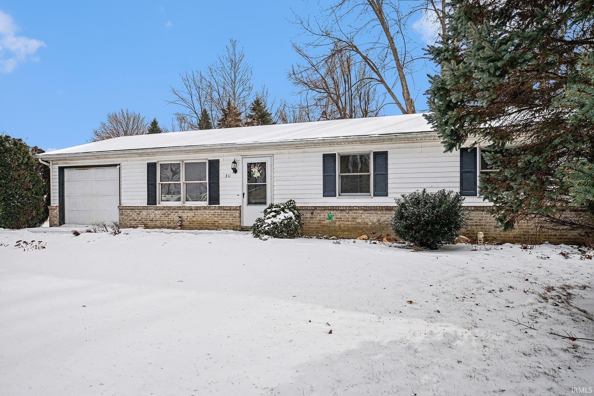 Image 1: Single story home with brick siding and a garage, Front Of Structure