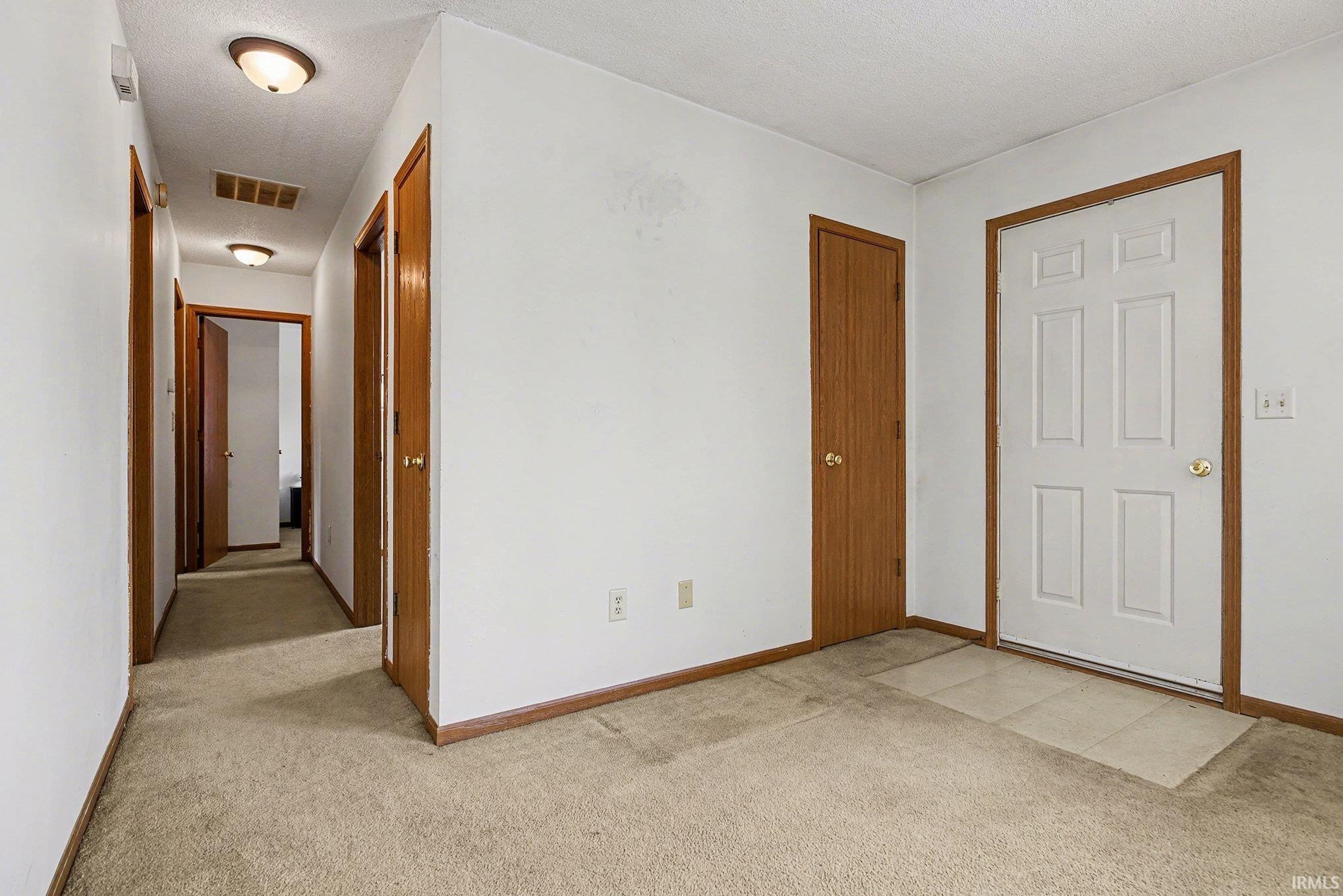 Image 3: Hallway featuring light carpet and a textured ceiling, Hallway