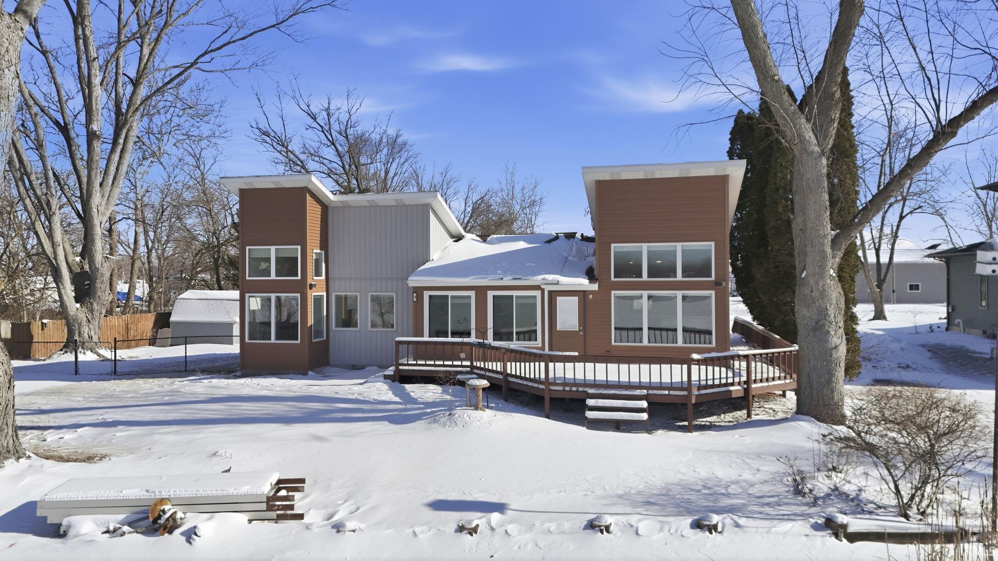 Image 2: Snow covered lake front of property featuring a wooden deck, Lake Front