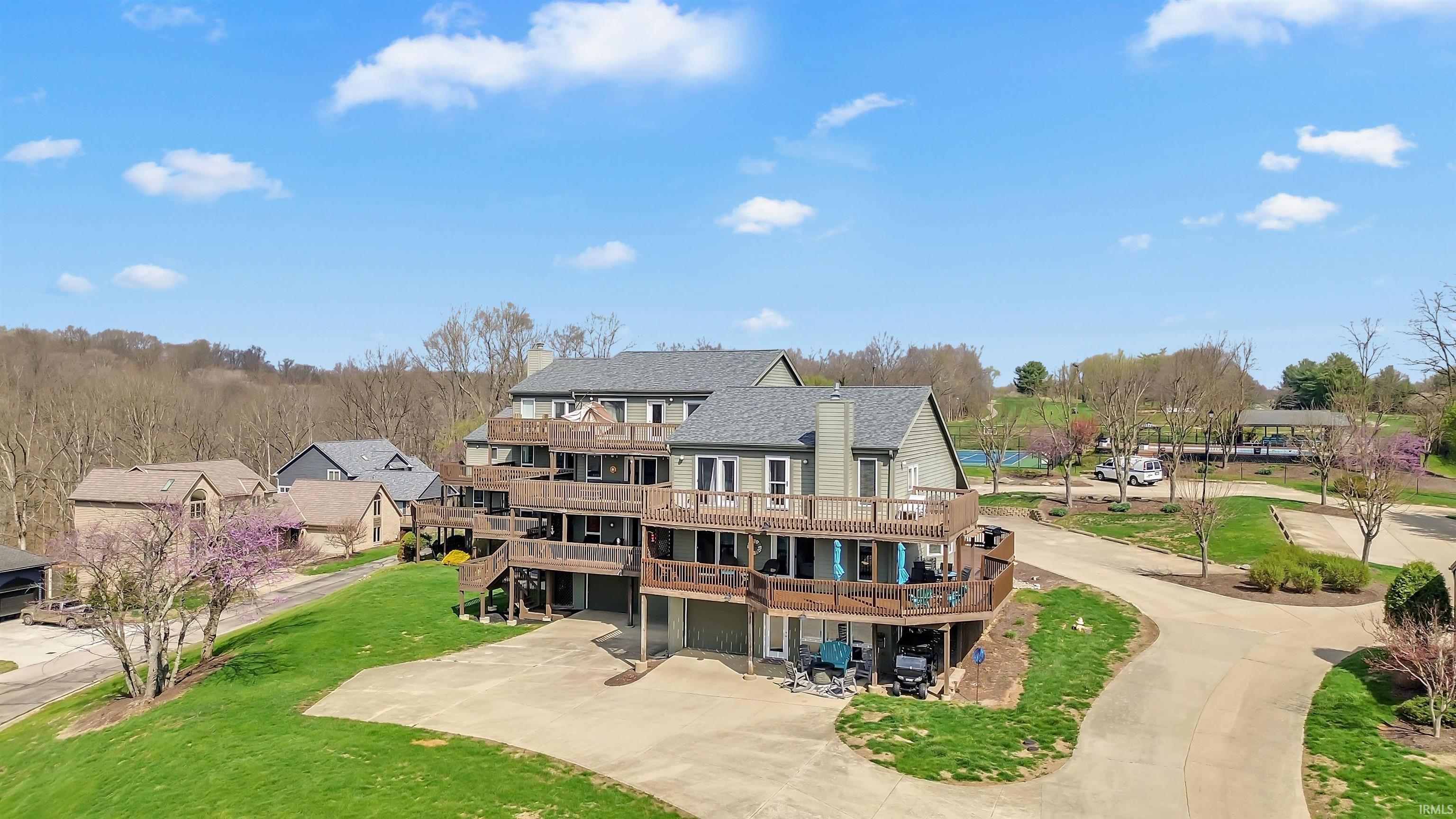 Image 0: Back of house featuring a deck, a yard, driveway, and roof with shingles, Back Of Structure Image 0: Back of house featuring a deck, a yard, driveway, and roof with shingles, Back Of Structure