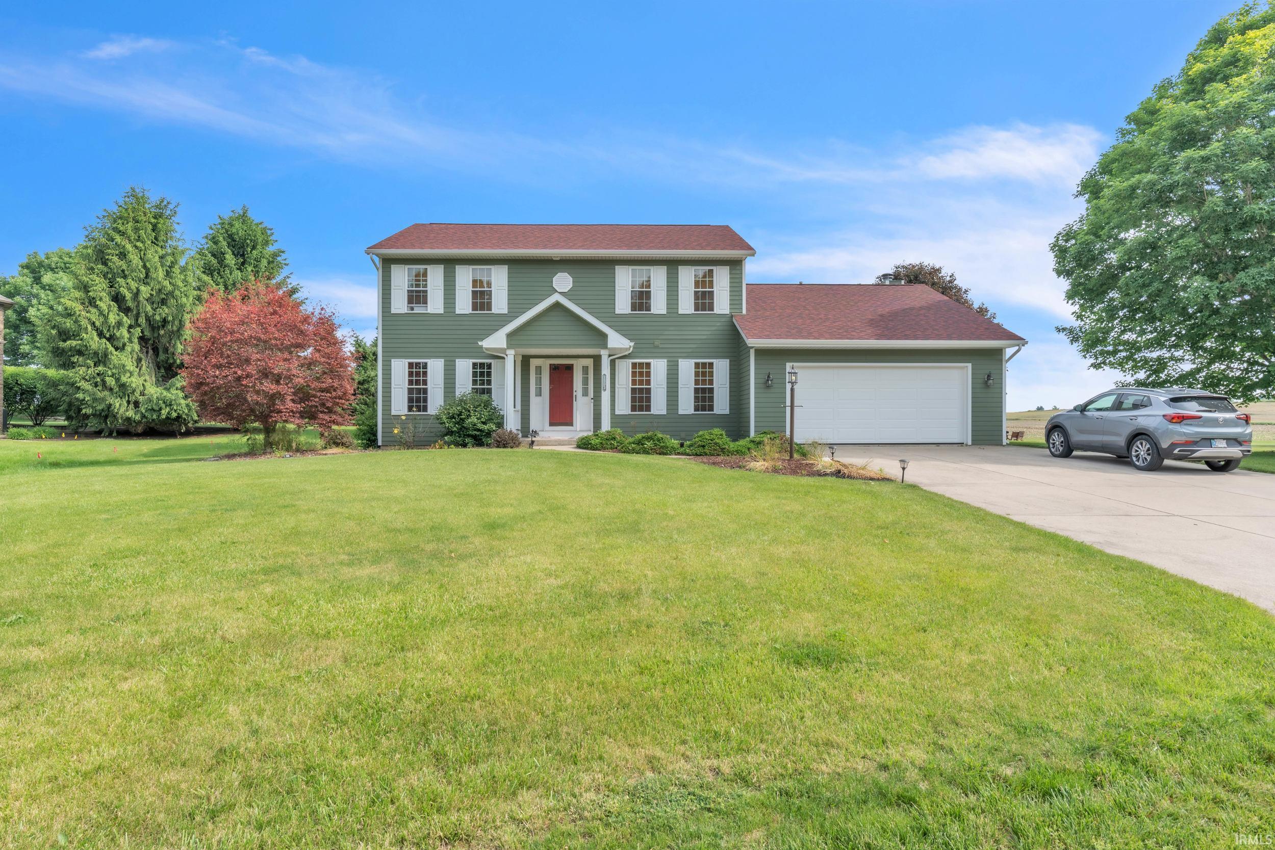 Image 0: Two-story residence with green siding, white trim, and a red front door, Front Of Structure