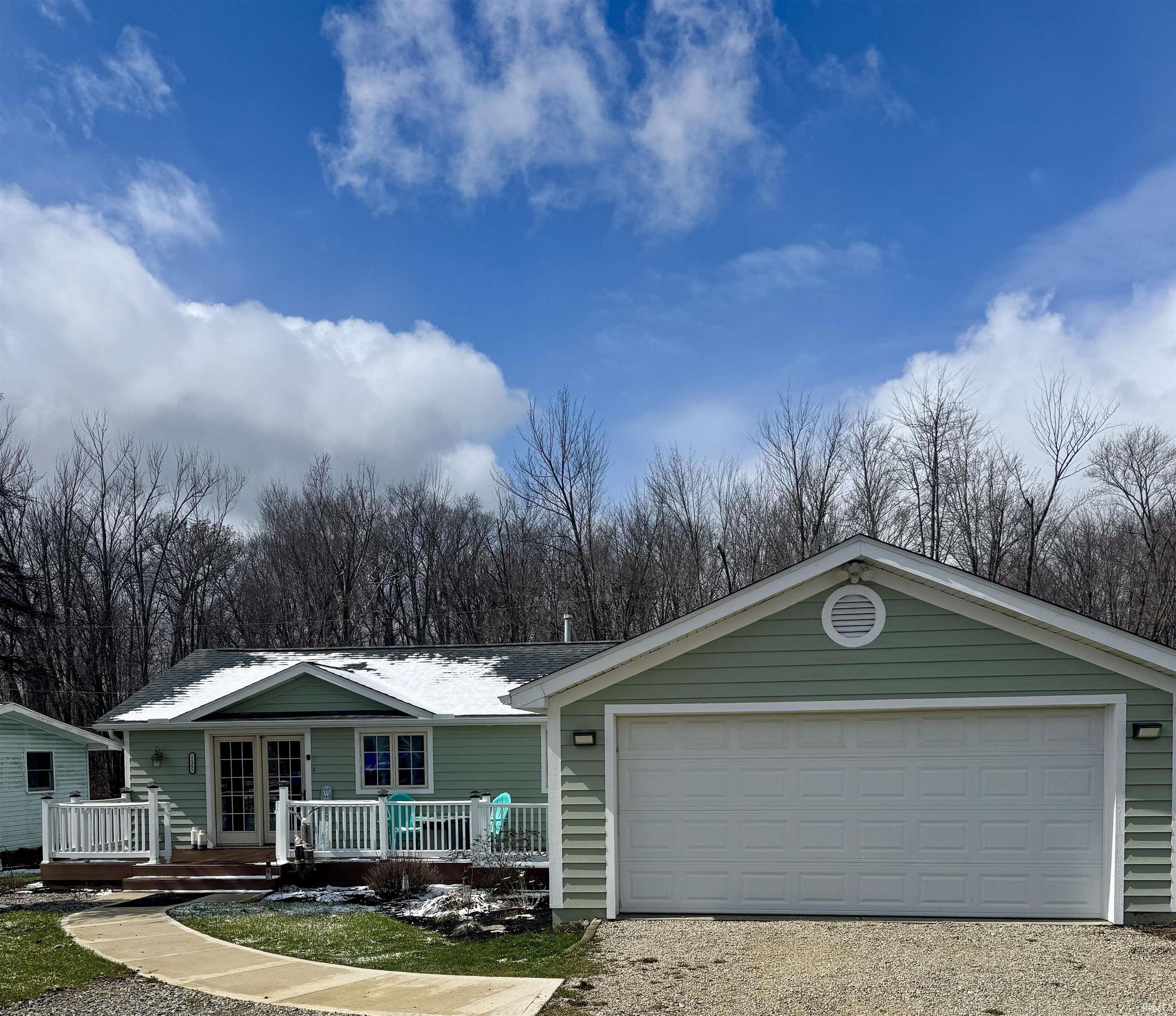 Image 0: Single story home with driveway and a deck, Front Of Structure