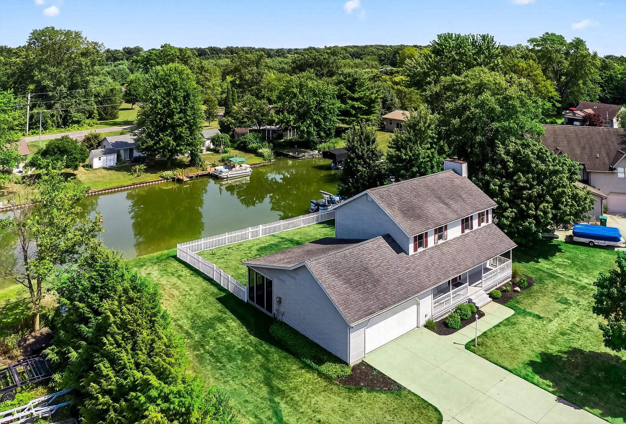 Image 0: View of subject property featuring a nearby body of water and a tree filled landscape, Aerial View
